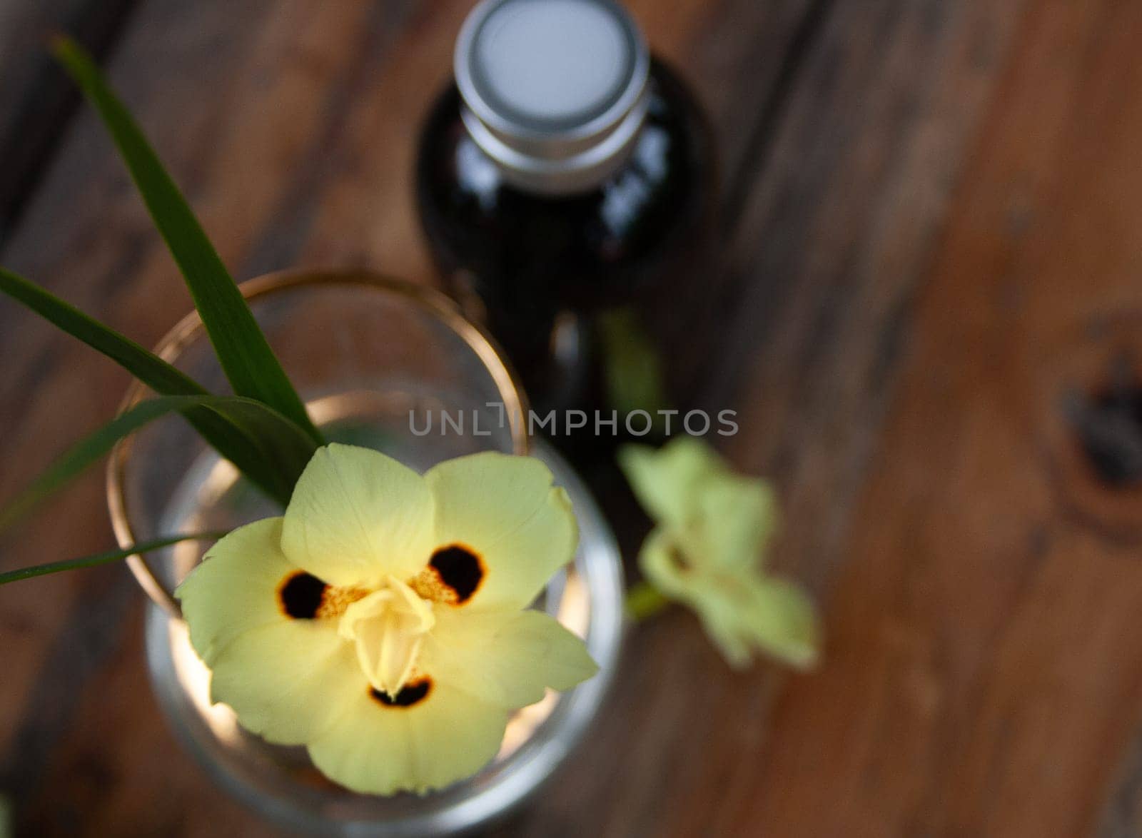 Aroma diffuser on wooden table with yellow floral decoration. Brown wooden background.Scenital photo