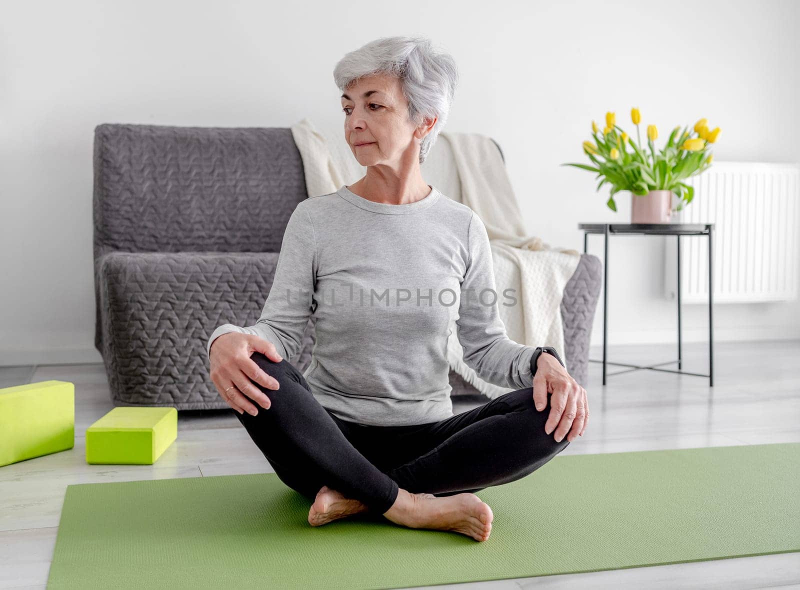 60 years old Woman Practices Yoga At Home by tan4ikk1
