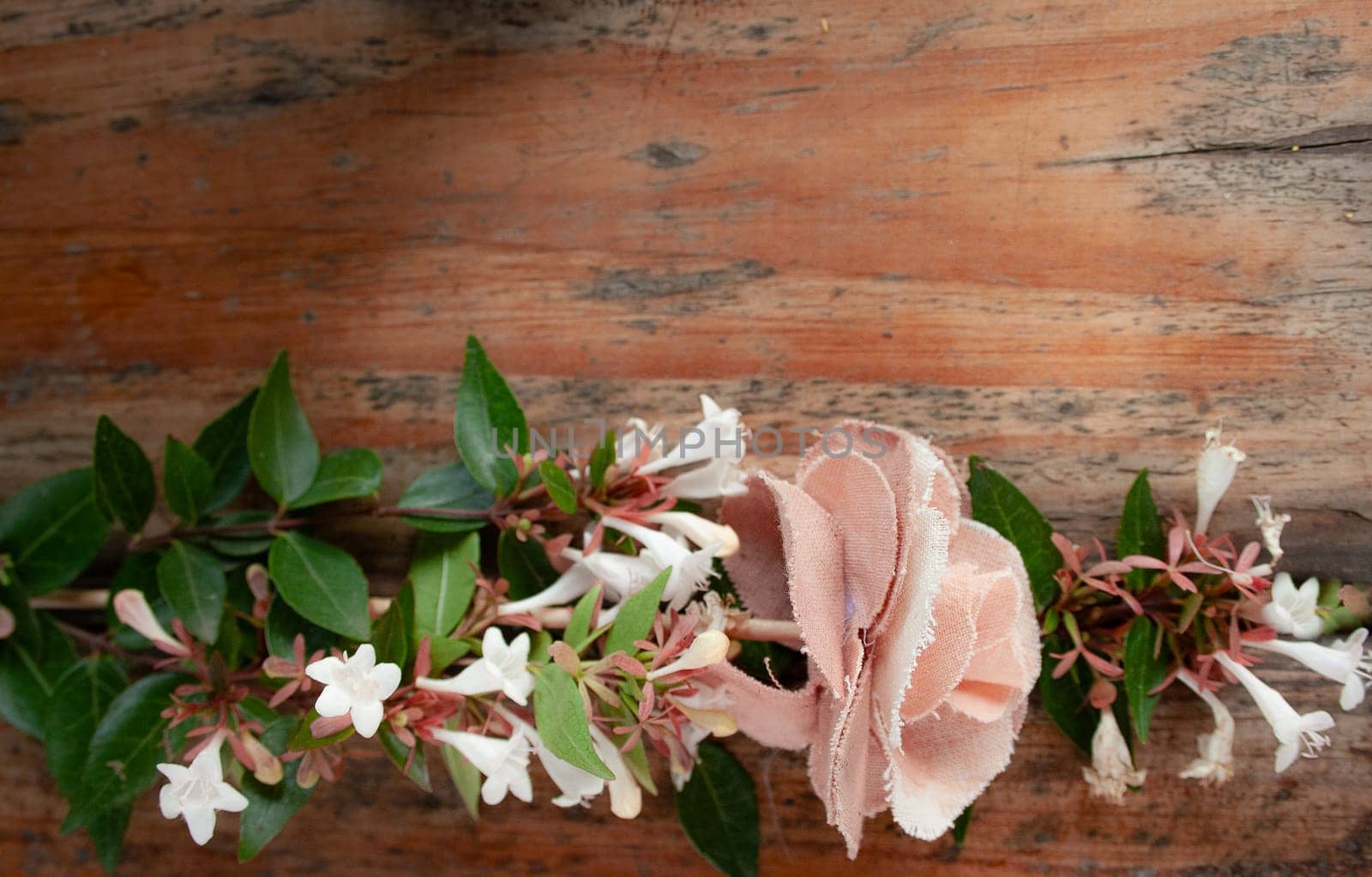 Bouquet of white flowers mixed with a fabric flower on wooden background. by VeroDibe