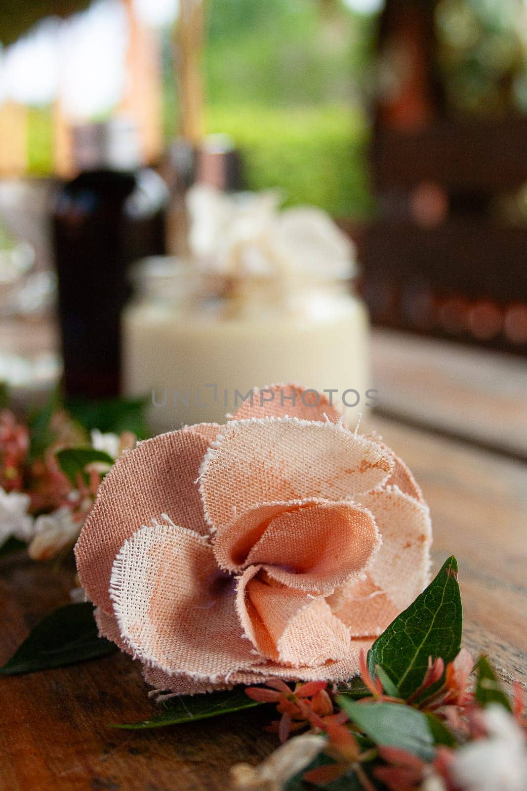 Close-up of pink fabric rose and white flowers on rustic table.Blurred backgound by VeroDibe