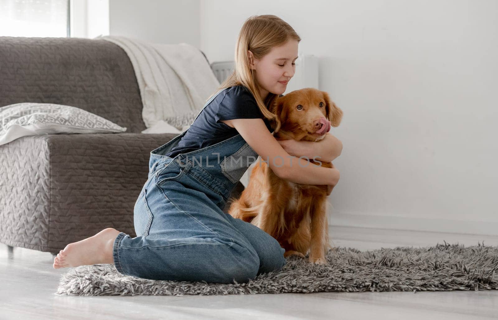 Small Girl Hugs Nova Scotia Retriever At Home On Floor, Nova Scotia Retriever Toller