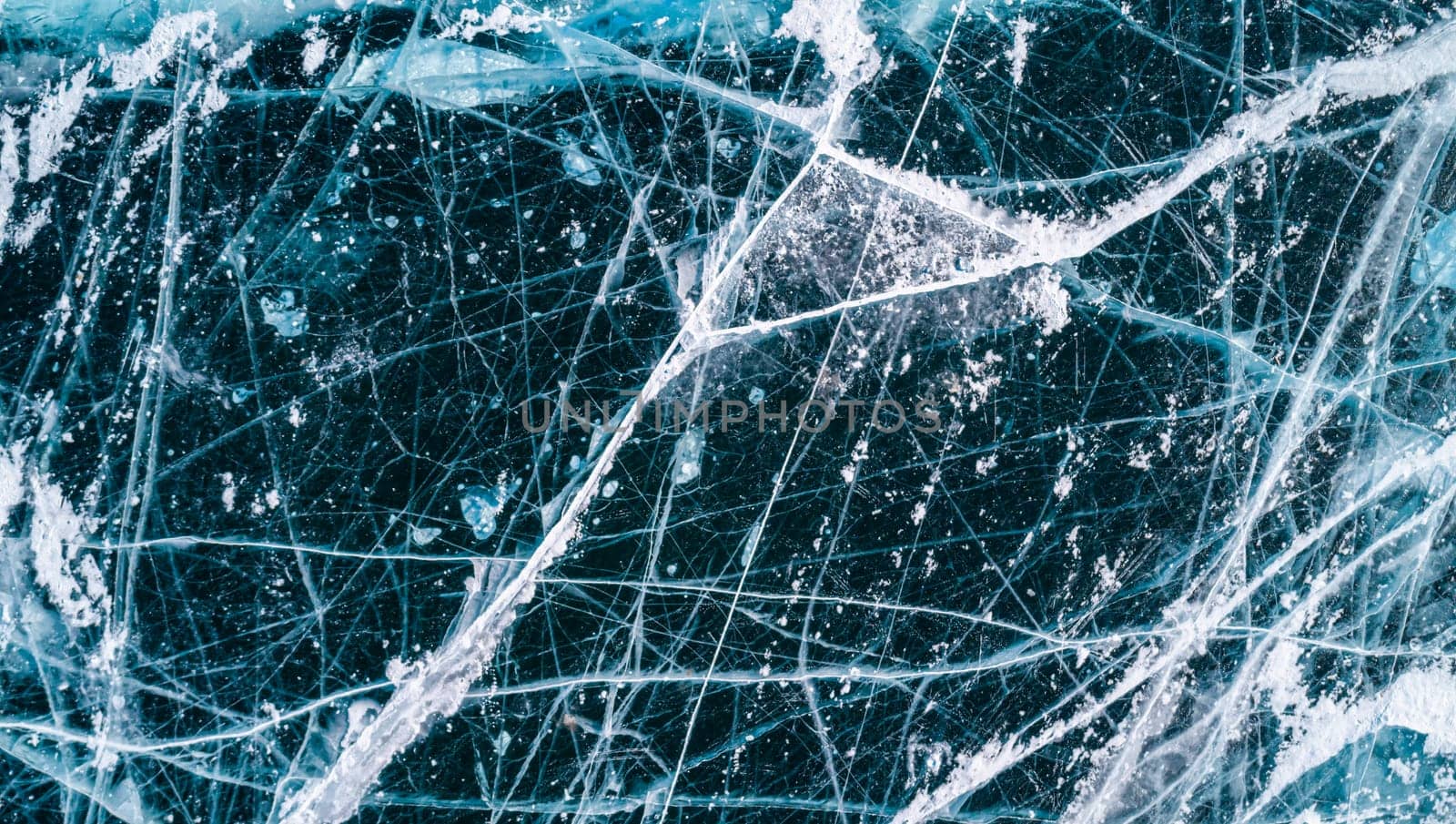 Aerial top down view on the blue cracked ice of the lake Baikal. Winter landscape, frozen lake. Ice kingdom.