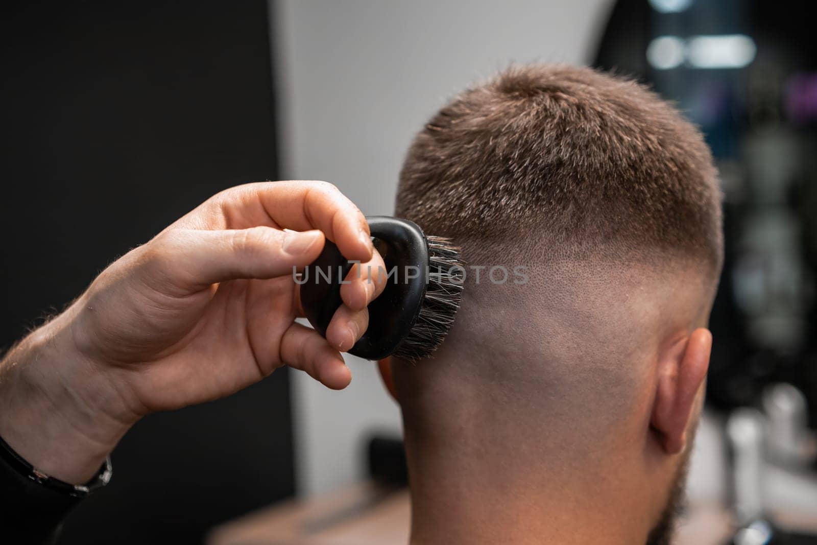 Hairstylist removes hair behind client ear with shaver by vladimka