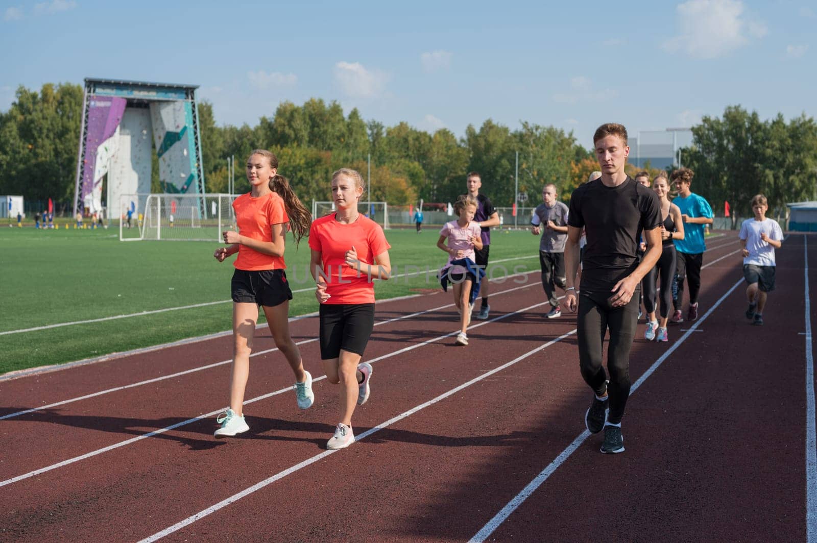 Group of young athletes training at the stadium. School gym trainings or athletics