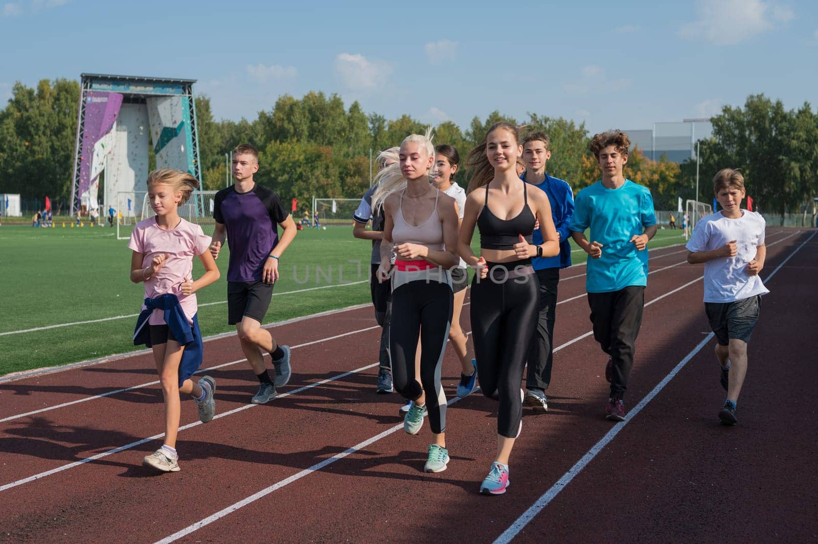 Group of young athletes training at the stadium. School gym trainings or athletics