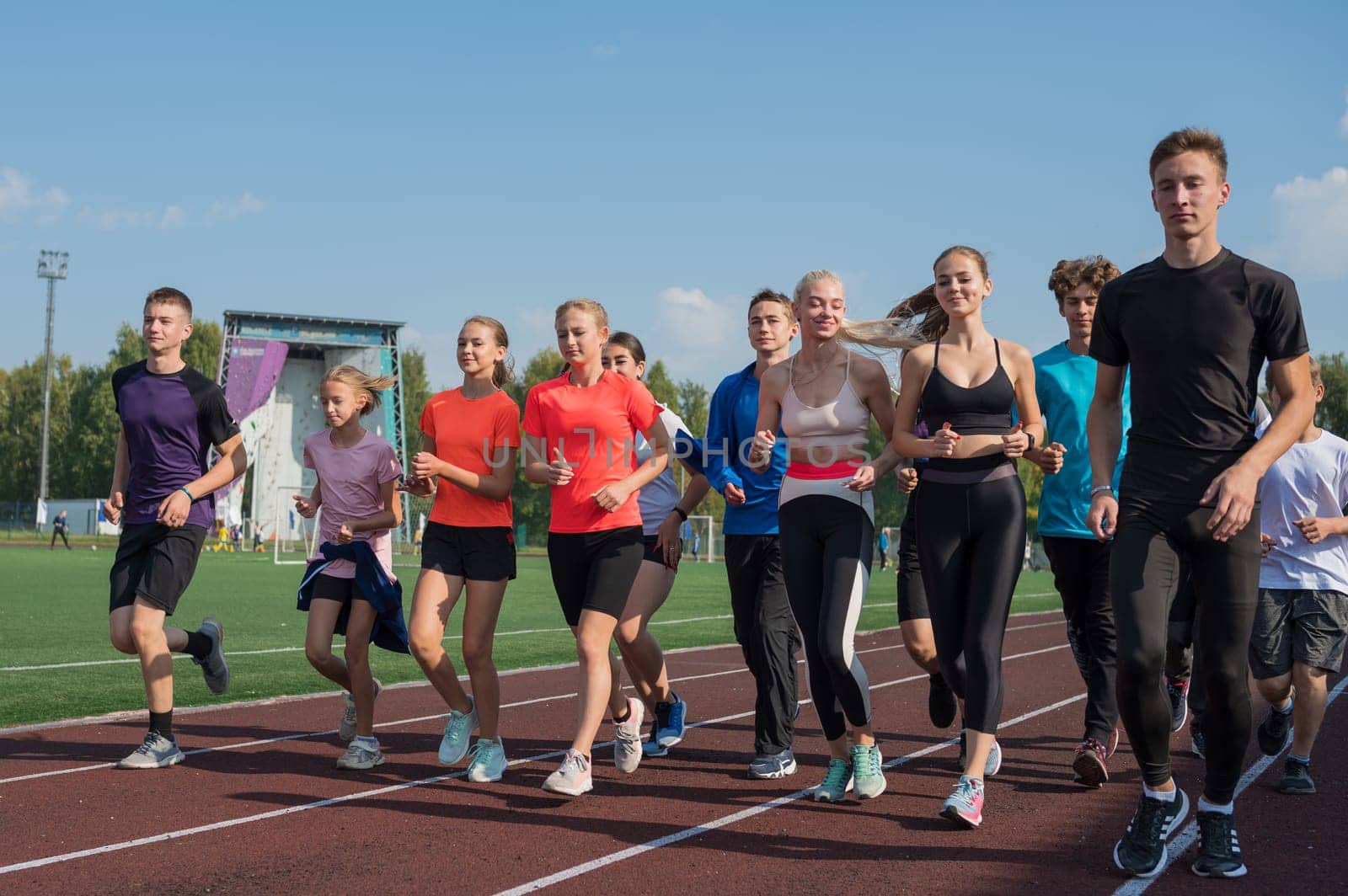 Group of young athletes training at the stadium. School gym trainings or athletics