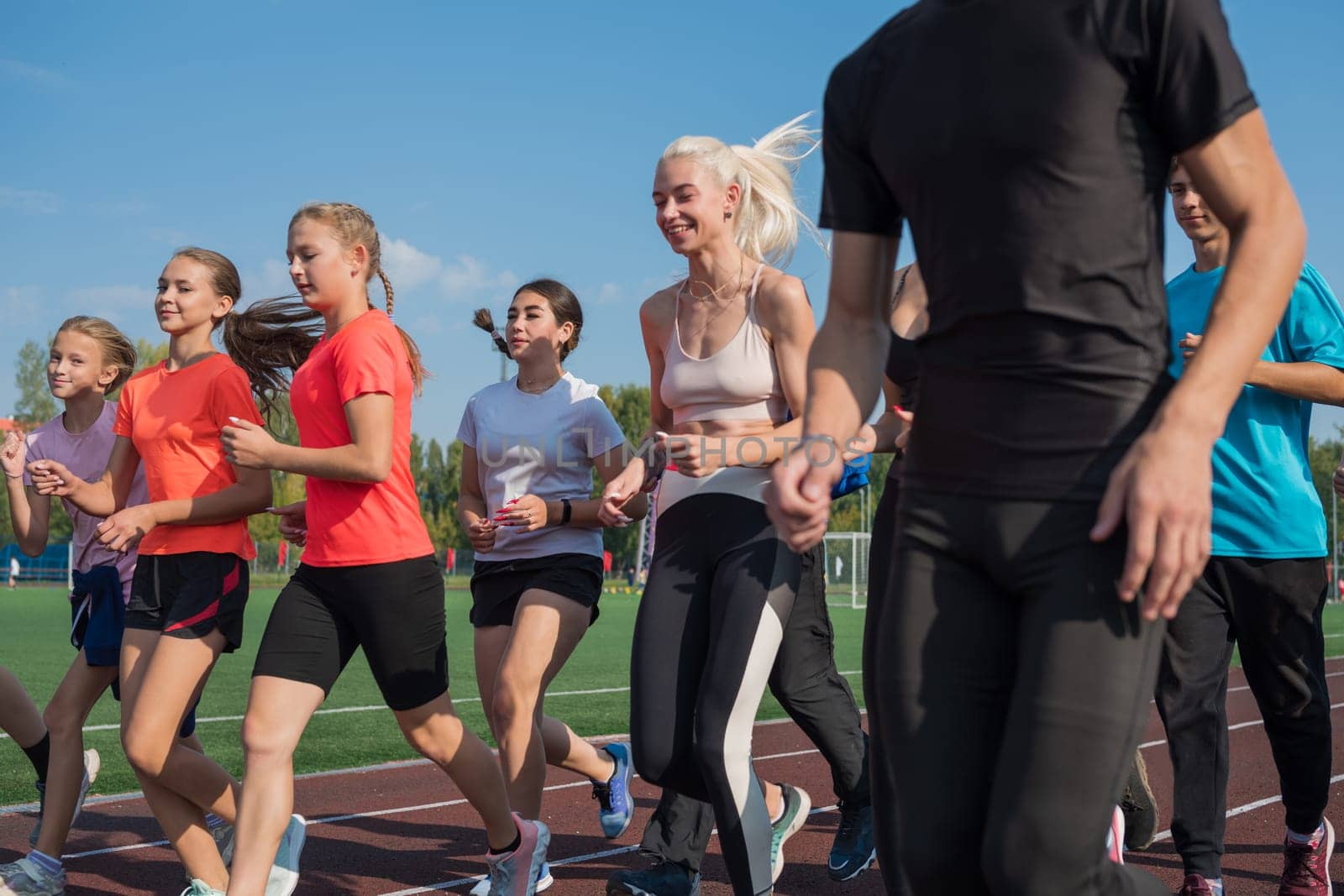 Group of young athletes training at the stadium. School gym trainings or athletics