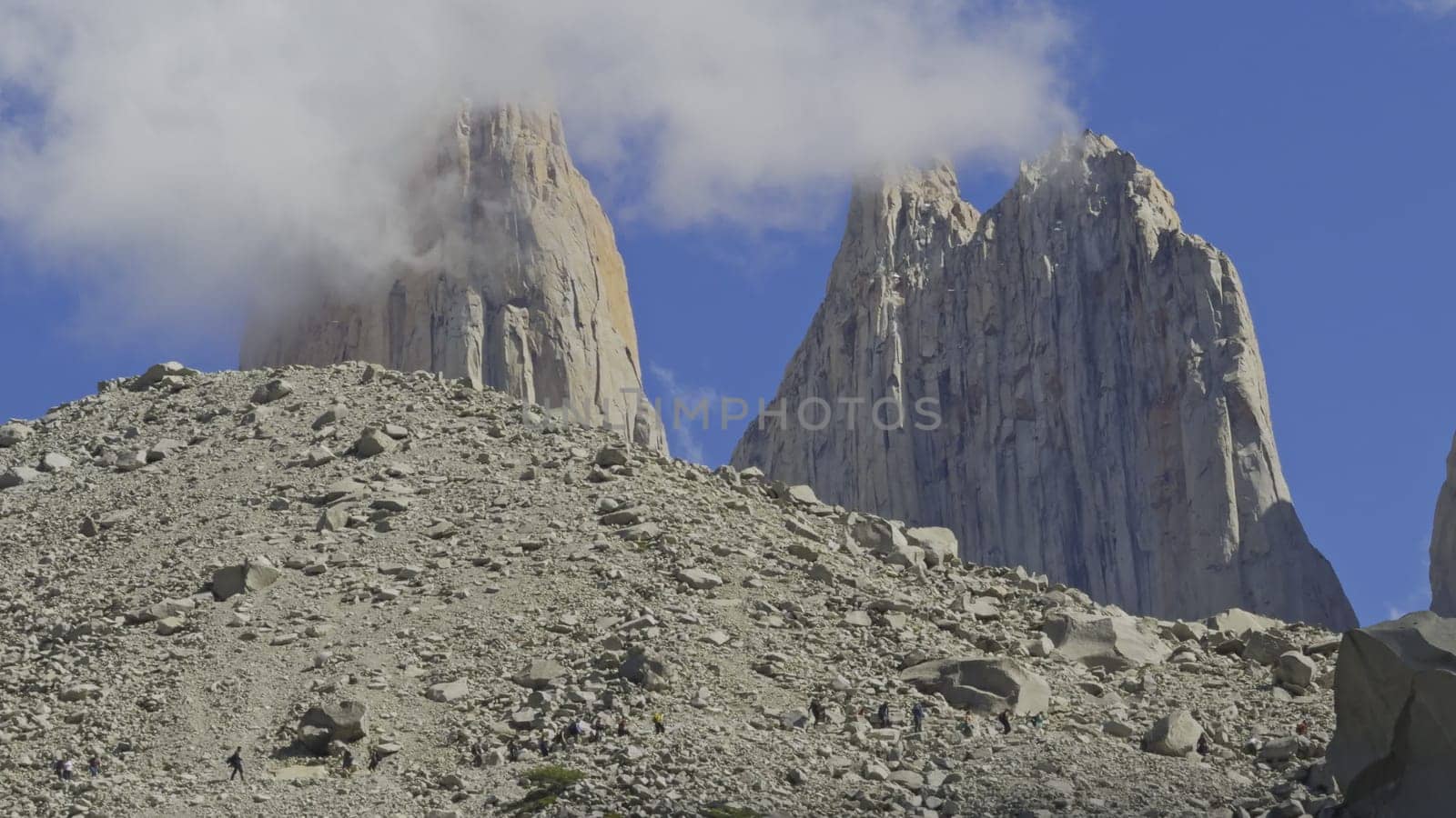 Hikers trek carefully through rough terrain aiming for the iconic Torres del Paine vista.