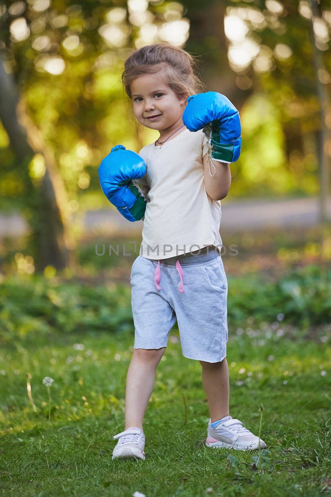 Charming child doing boxing in the backyard on the Sunset.