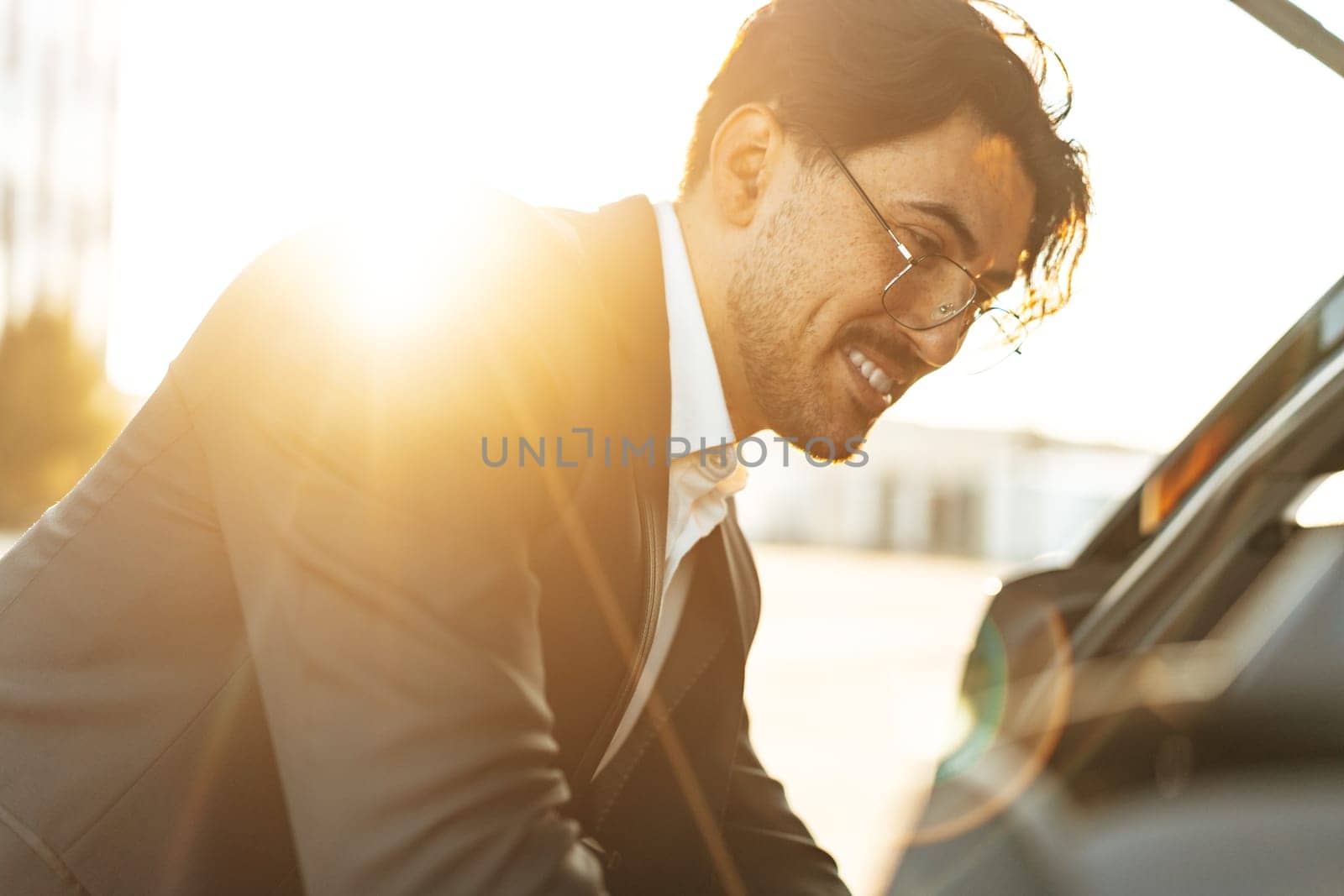 Successful businessman taking luggage from the car trunk by Fabrikasimf