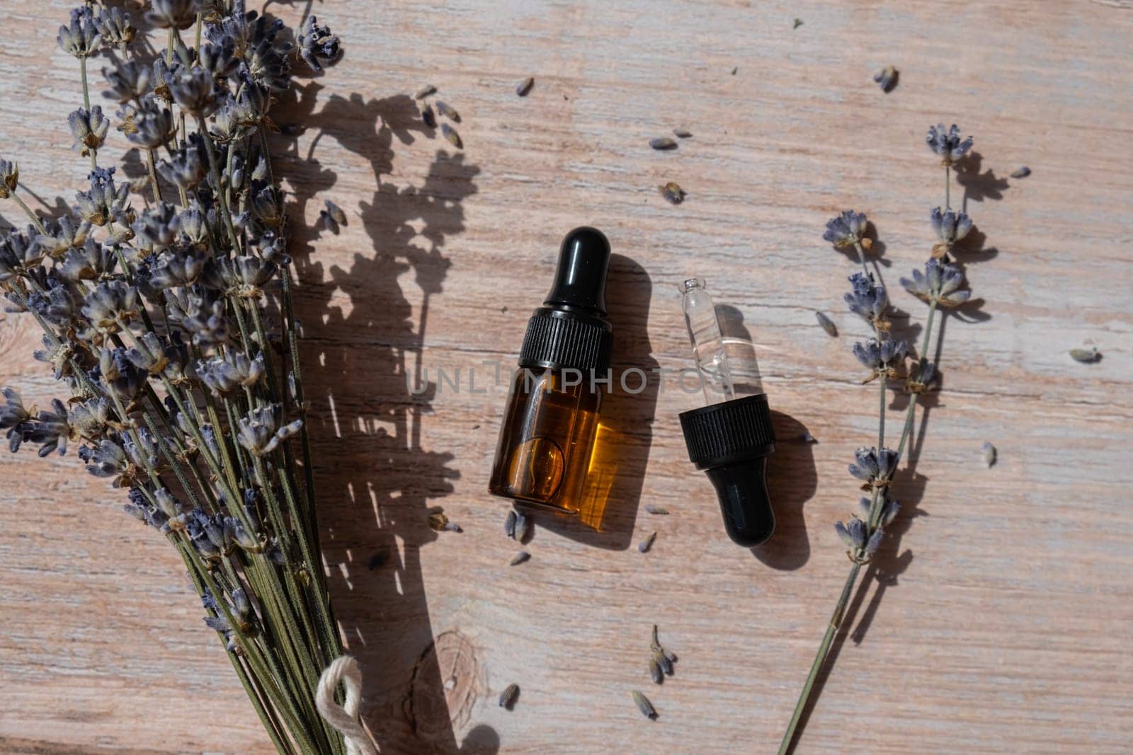 Lavender flowers with dropper glass bottle of essential oil. Concept of alternative medicine. Herbal natural detox treatment. Stress relief calming mental health products. Sustainable wellbeing