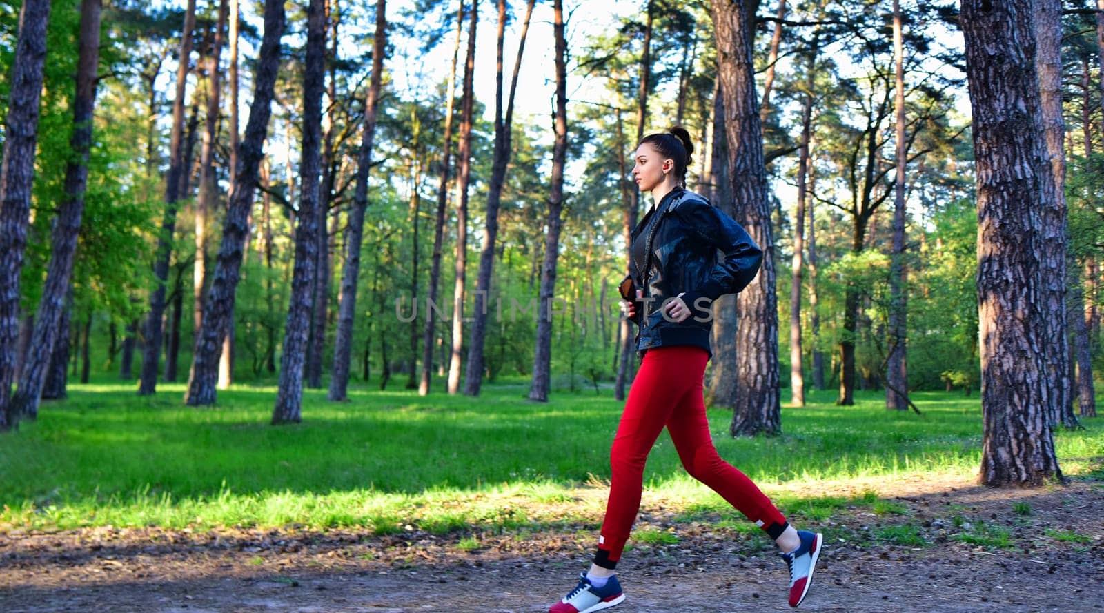 A young woman on a jog in the park. Jogging in nature