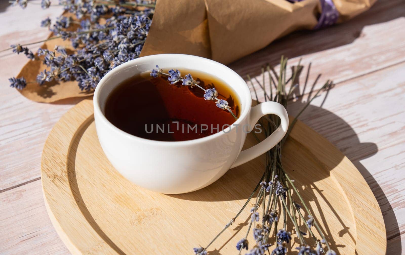 Healthy homemade cup of lavender tea. Organic natural home grown herb for teas. White cup of tea with dried lavender flowers. Healthy living wellbeing self care
