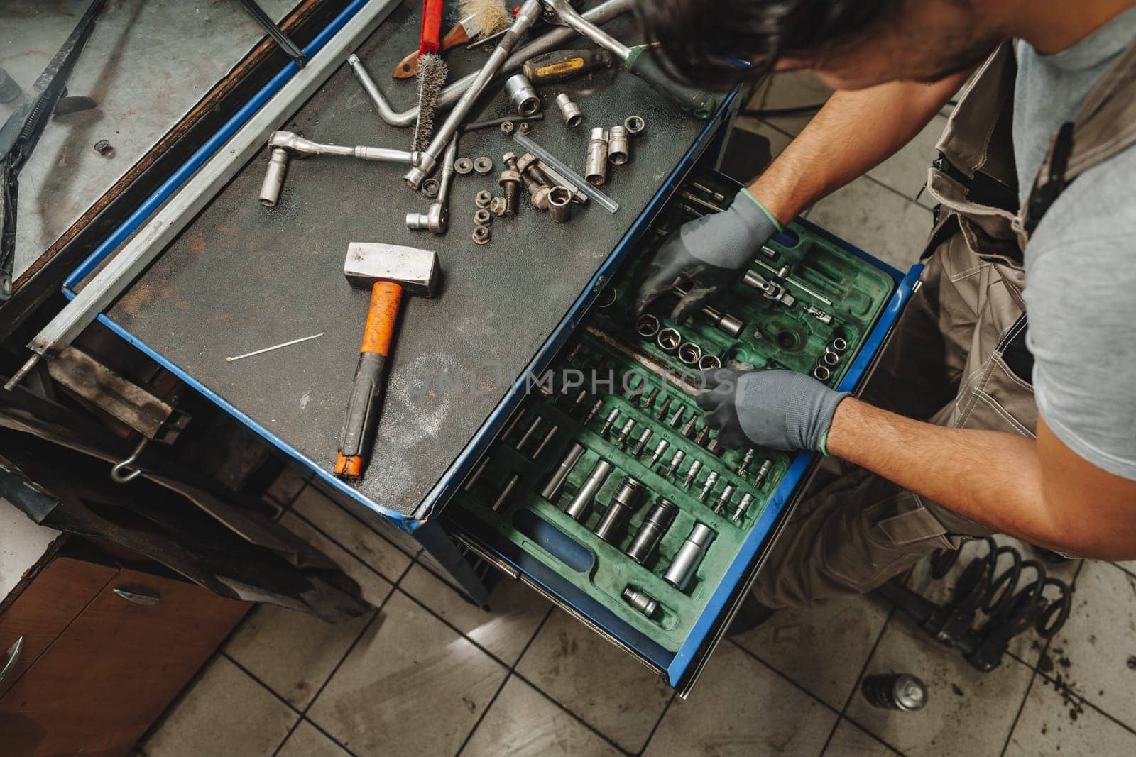 Male technician standing near tool table in car service close up