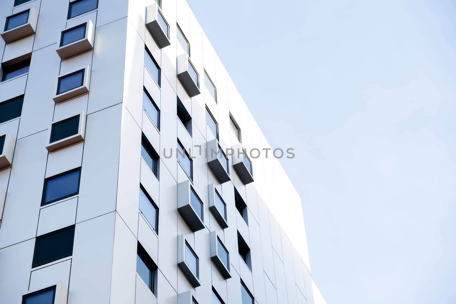 Modern white building with square windows. Multistory apartment building. Minimalistic Stylish living block of flats. Facades of modern office building. Exterior texture pattern. Visual art. Conceptual