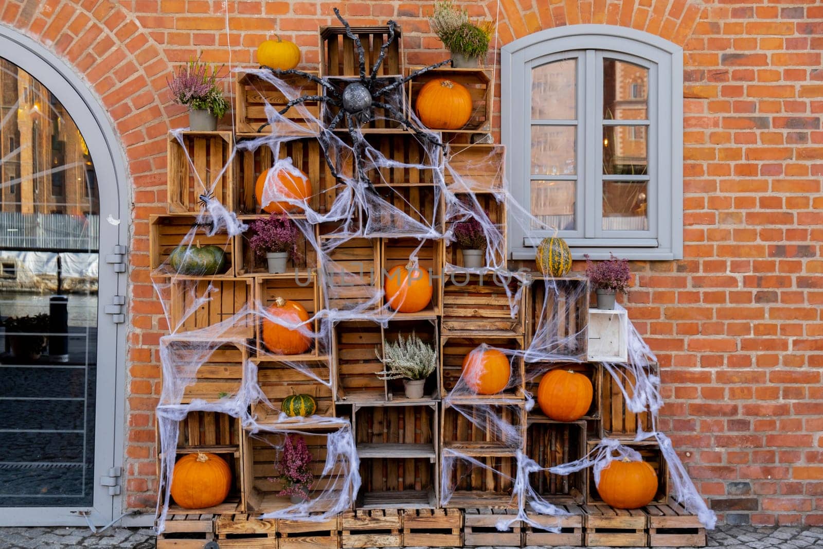 Exterior design cozy atmospheric halloween pumpkins in wooden boxes decorated on porch. Autumn leaves and fall flowers celebration holiday Thanksgiving October season outdoors in city