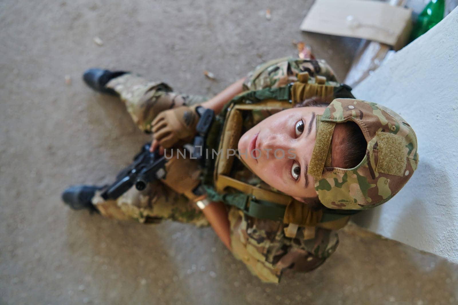 A woman in a professional military uniform sits in an abandoned building, ready for a dangerous mission, exuding bravery and determination by dotshock