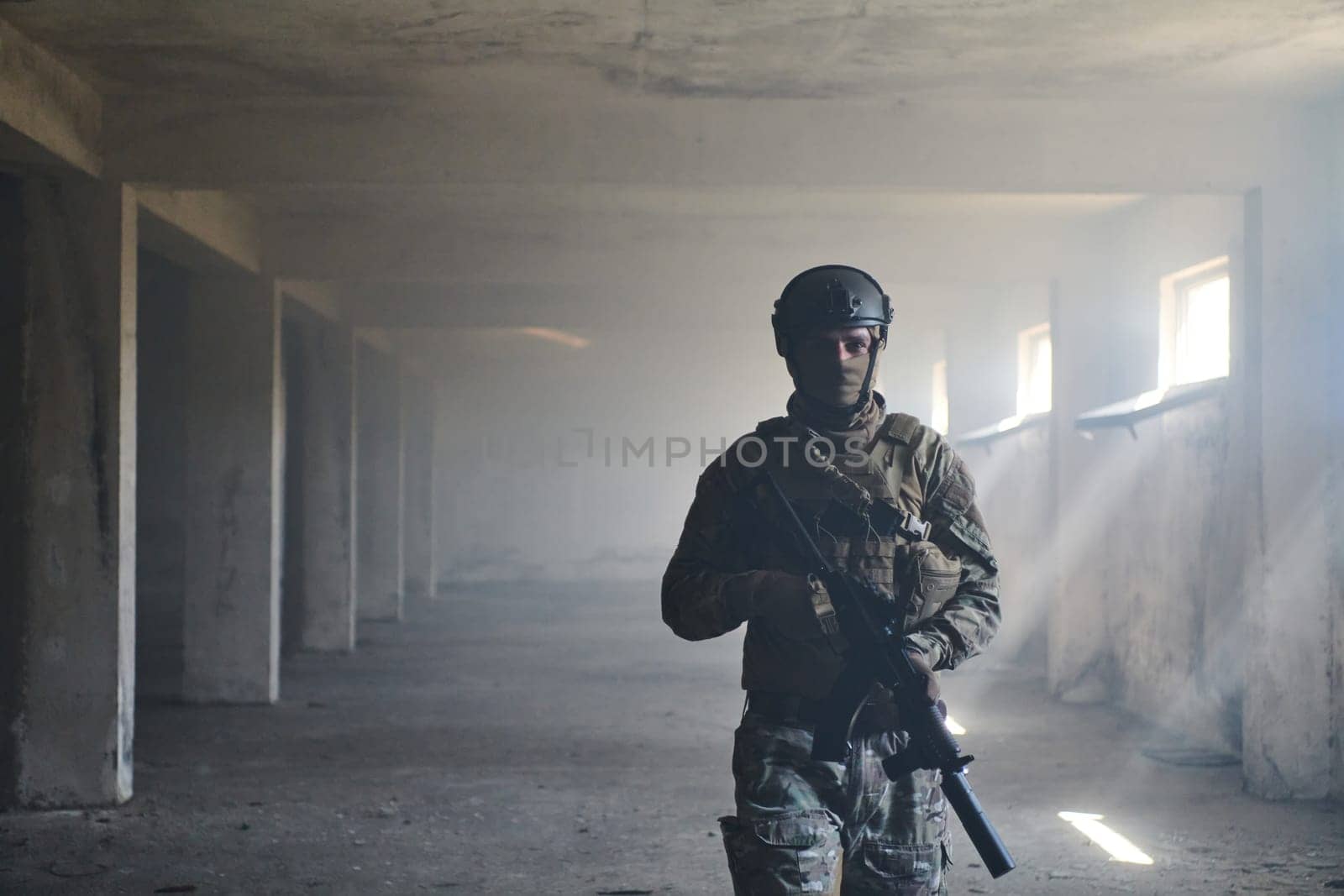 A professional soldier in an abandoned building shows courage and determination in a war campaign by dotshock