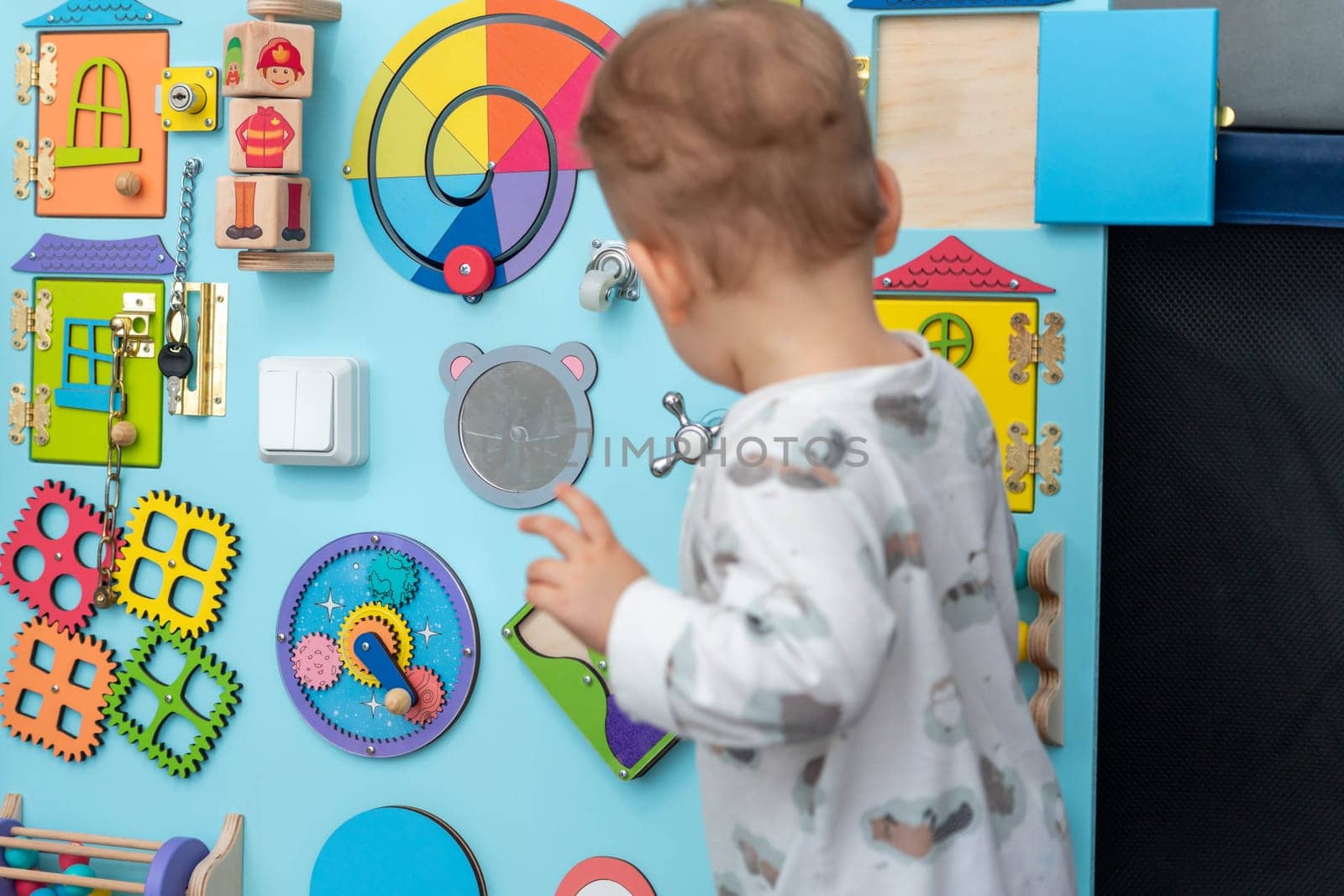 A child in front of a large board with interest selects elements for the game.