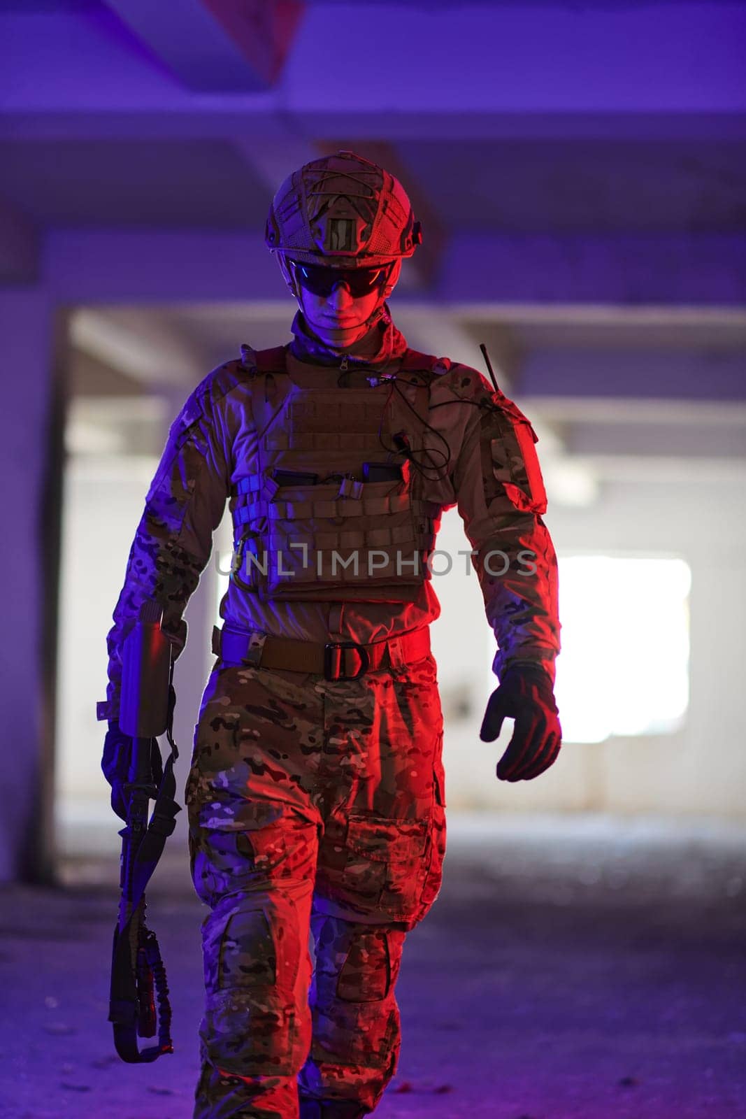 A professional soldier undertakes a perilous mission in an abandoned building illuminated by neon blue and purple lights.