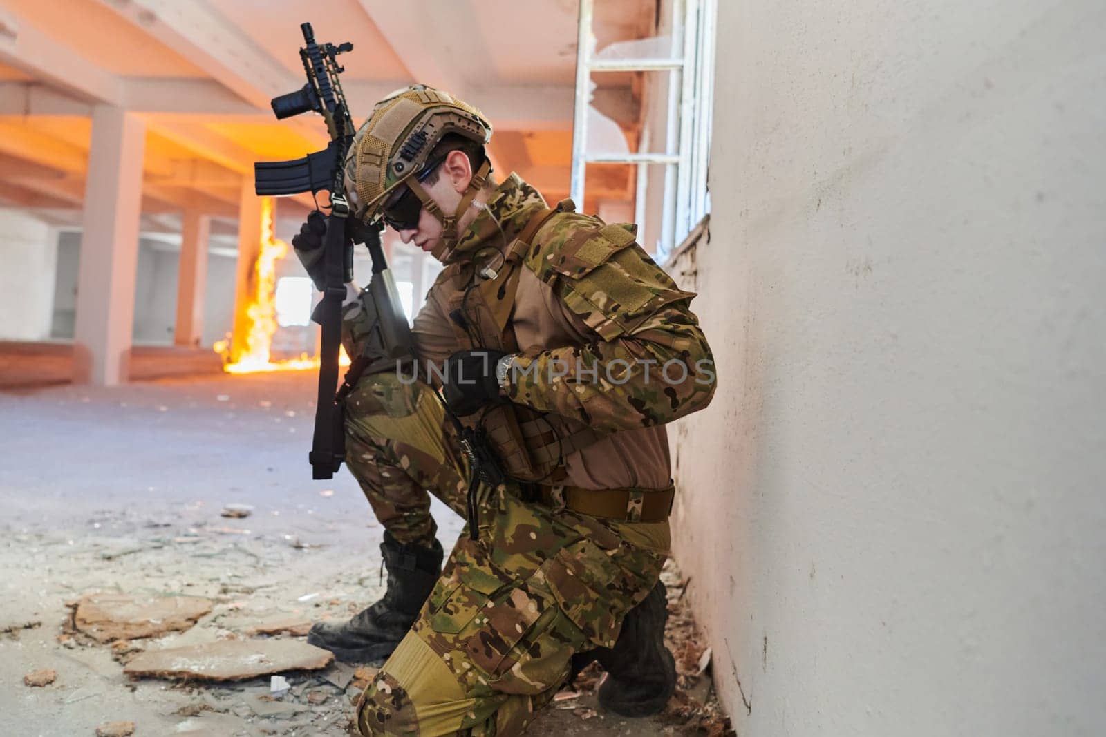 soldier in action near window changing magazine and take cover.