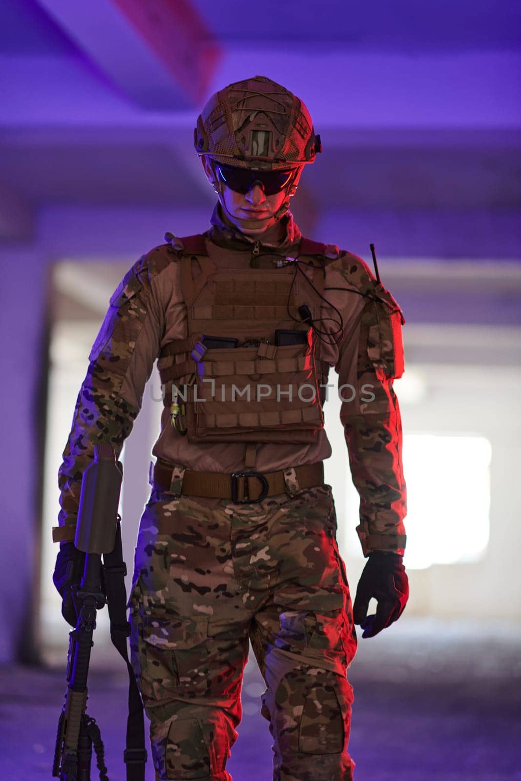 A professional soldier undertakes a perilous mission in an abandoned building illuminated by neon blue and purple lights.