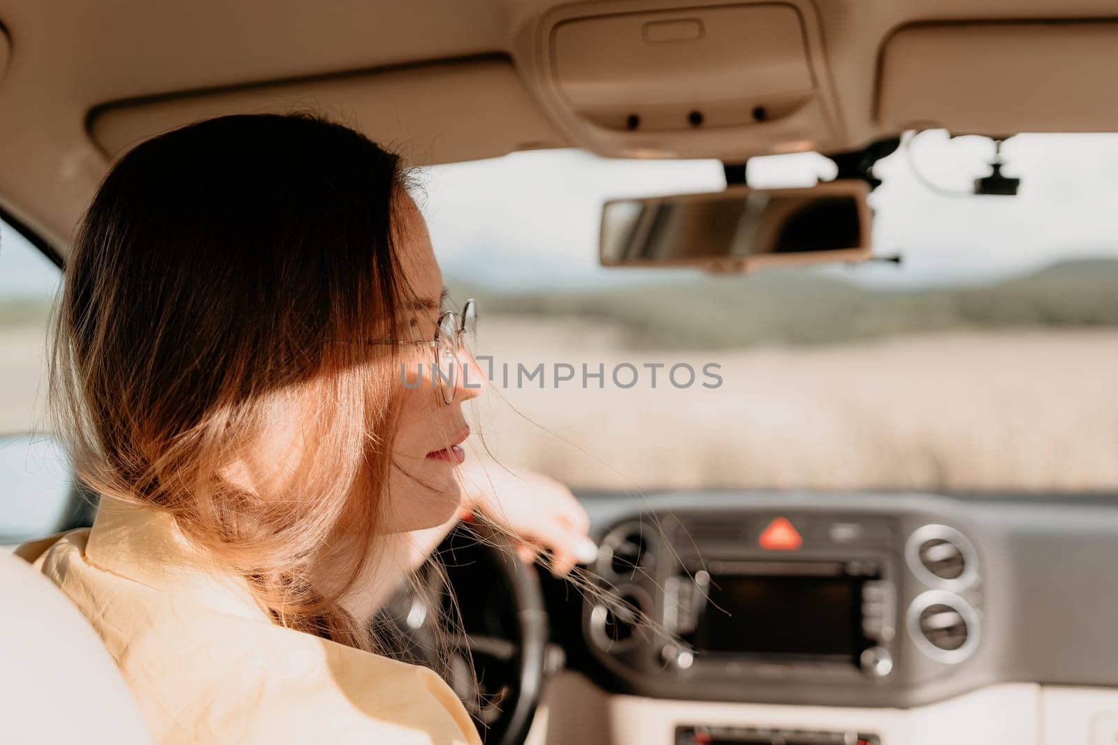 Relaxed business woman talking on video call on phone in automobile. Rested female professional saying bye on video chat in business car. Beautiful lady making video message in luxury car.