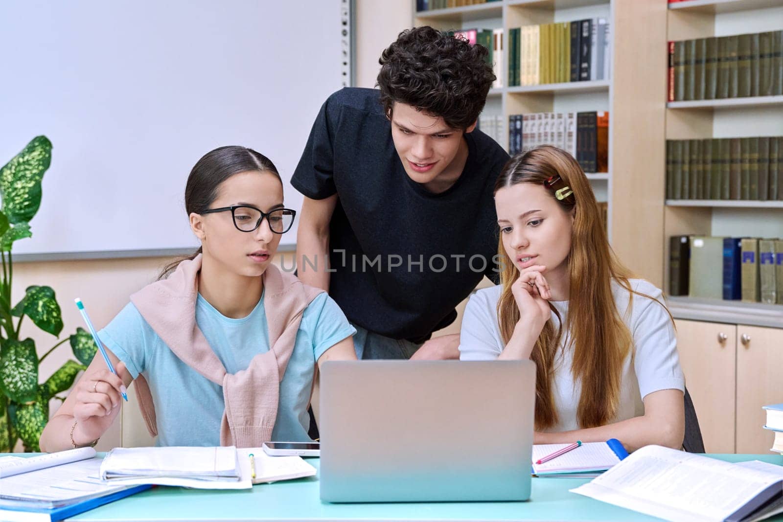 Group of high school students are studying in library class by VH-studio