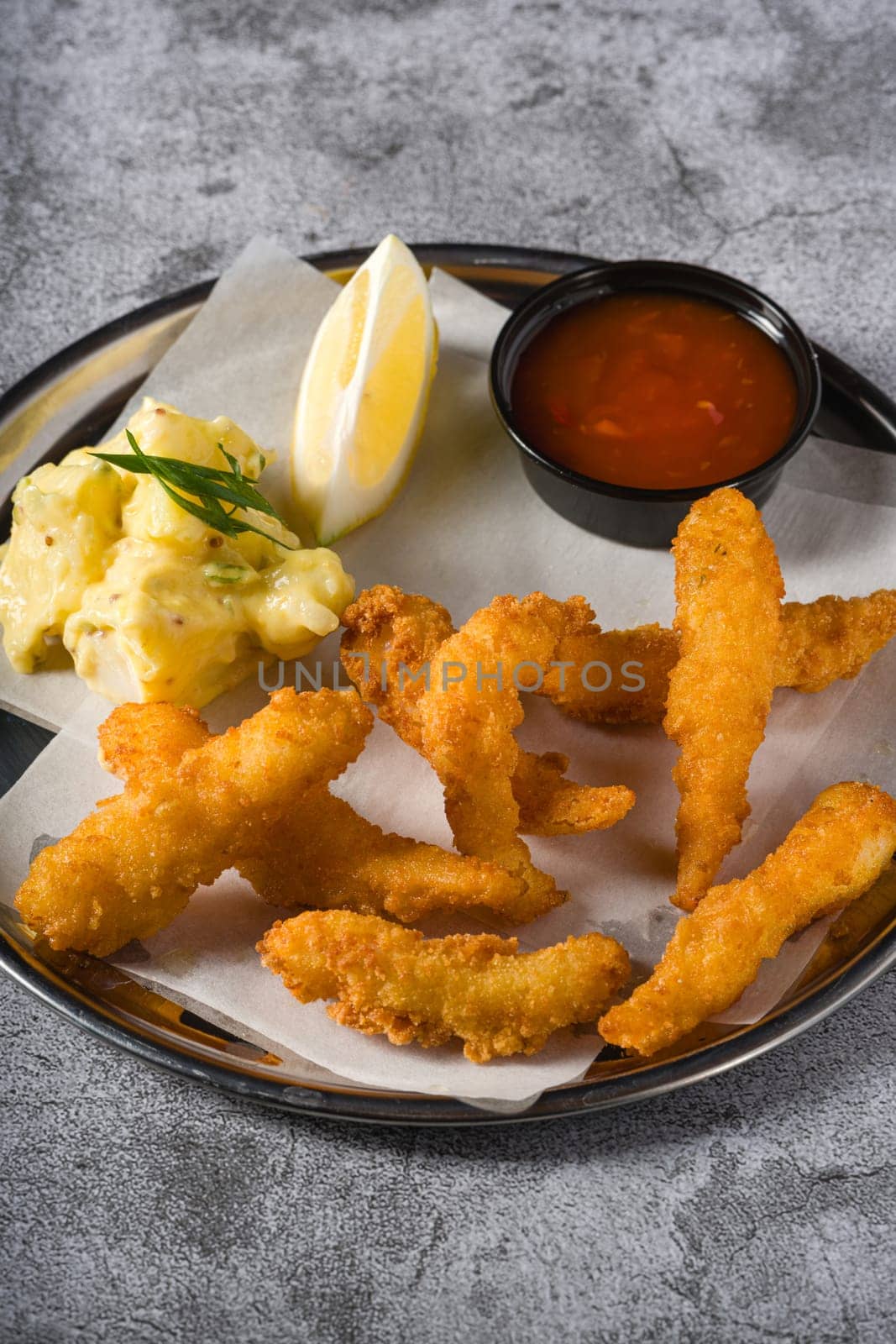 Deep fried shrimp tempura with potato salad on a metal plate by Sonat