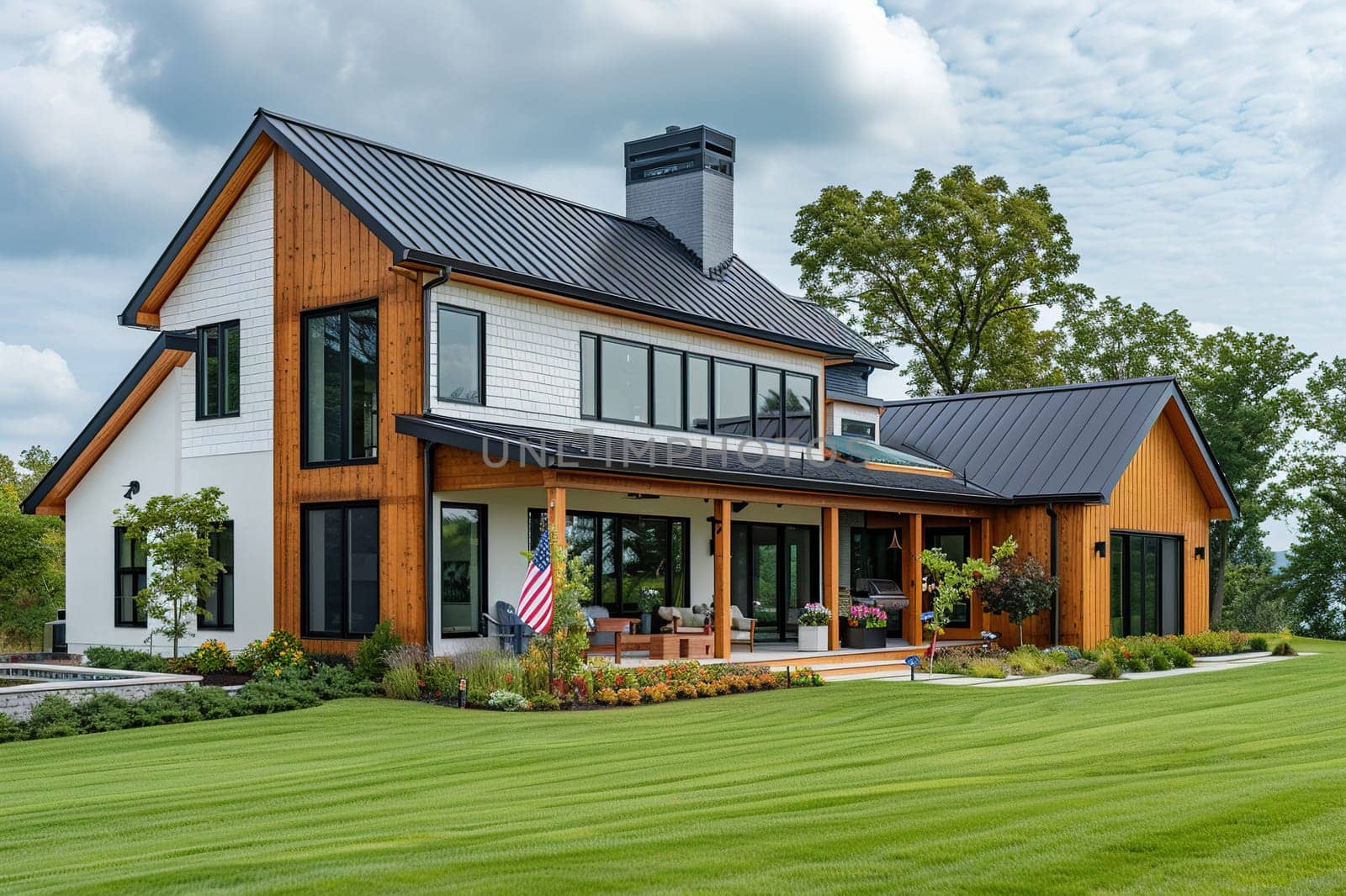A beautiful two-story American-style house on a green lawn with a usa flag.