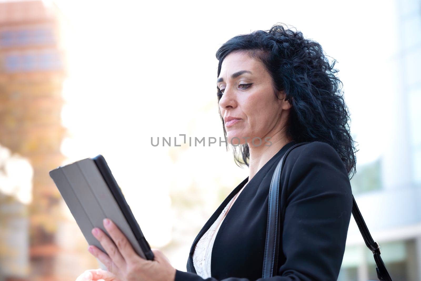 Portrait of a smiling middle-aged business woman with digital tablet in smiling hands looking at camera