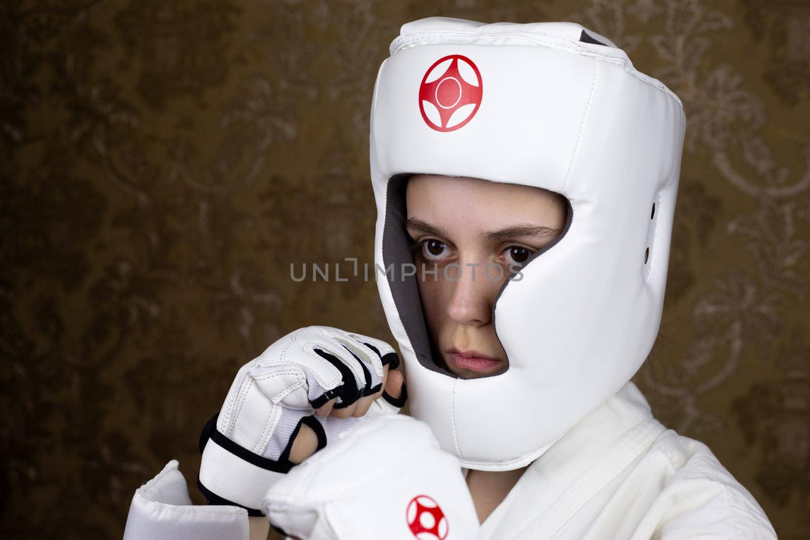 Portrait of girl in protective Kyokushin karate helmet and gloves by timurmalazoniia