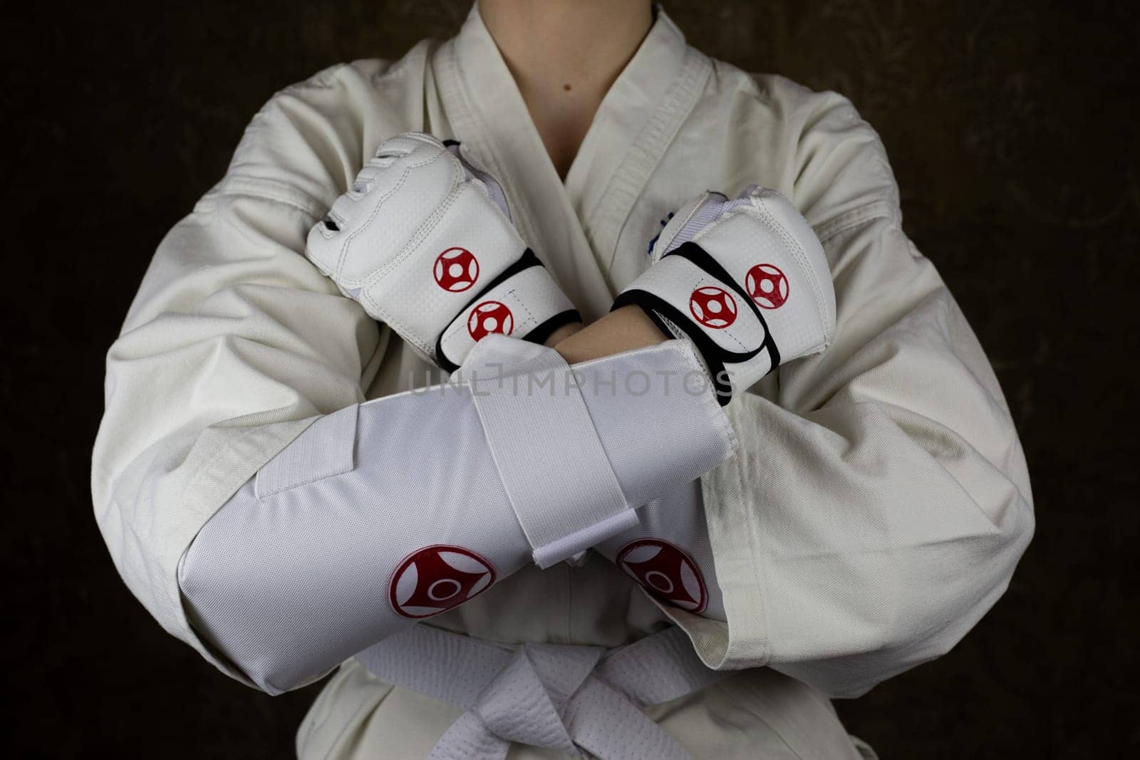 Girl in kimono and protective equipment in Kyokushin karate crossed her arms before greeting her opponent by timurmalazoniia