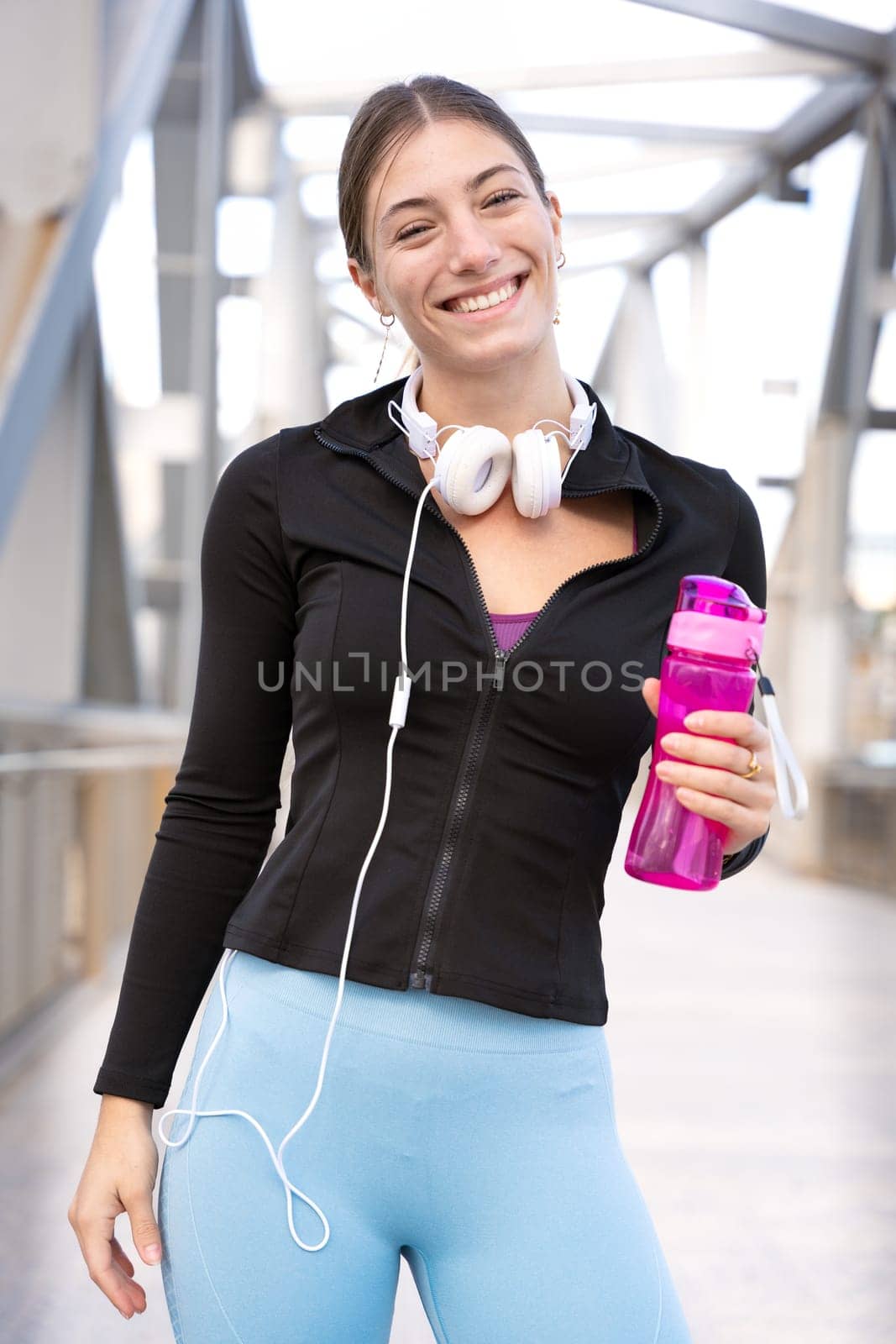 Smiling man looking at camera woman resting during his morning workout outdoors.