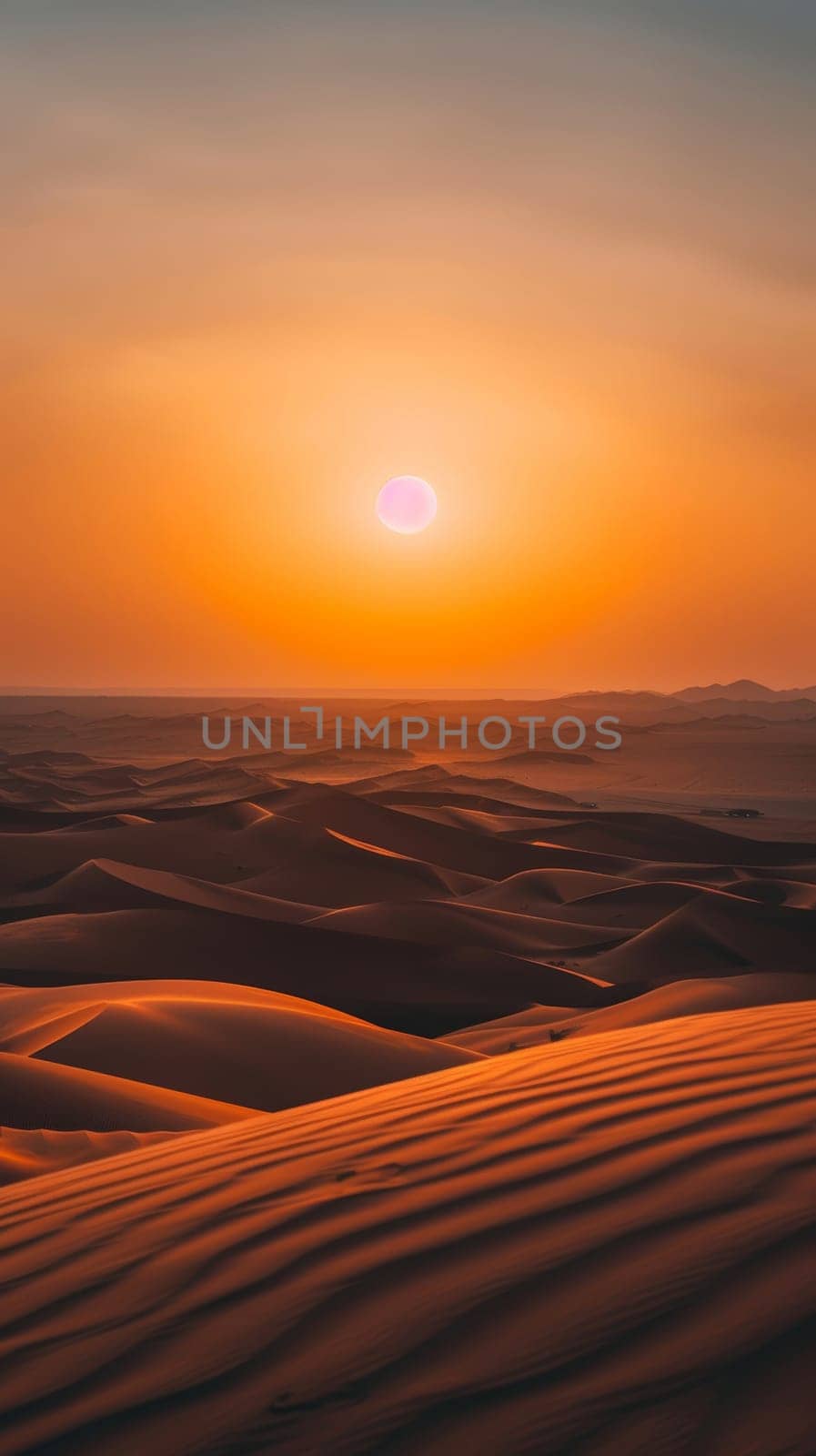 As the sun descends, its soft glow bathes the desert in a tranquil orange. Gentle winds sculpt the sands into waves of shadow and light