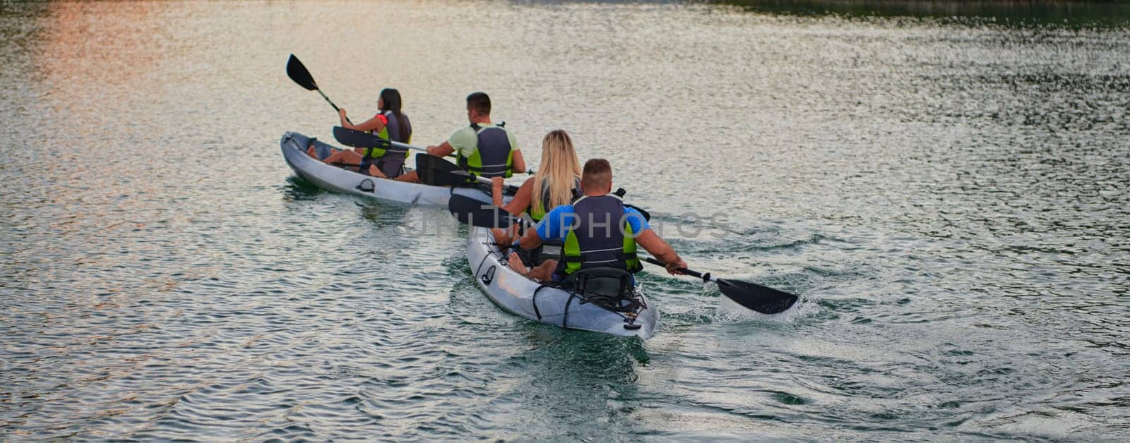 A group of friends enjoying having fun and kayaking while exploring the calm river, surrounding forest and large natural river canyons.