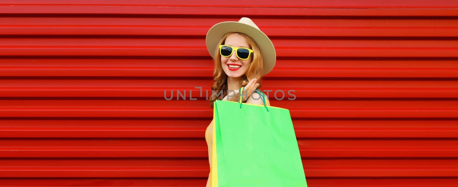 Shopping day! Stylish beautiful happy smiling young woman with green shopping bags, wear summer hat by Rohappy