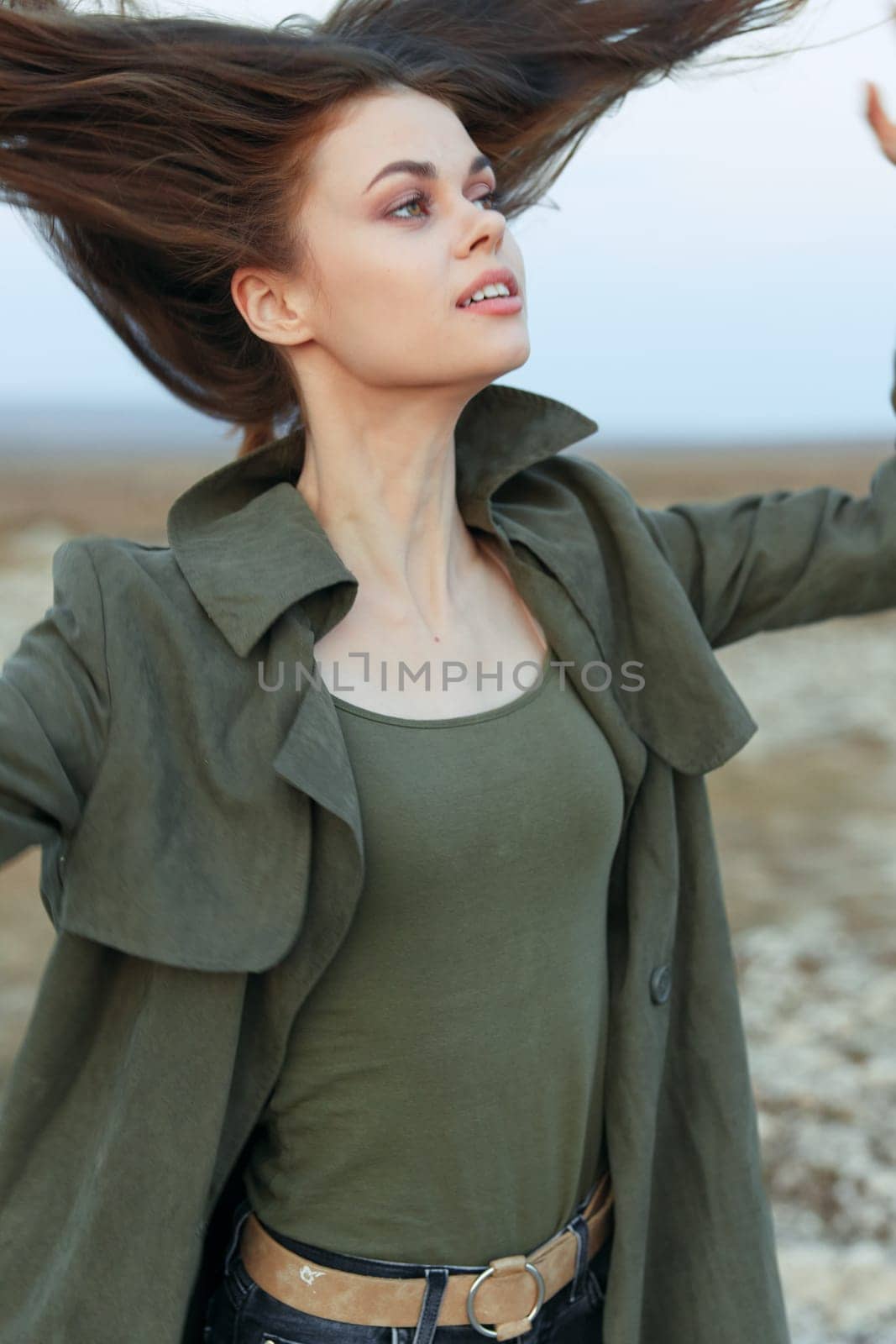 carefree woman with flowing hair in desert landscape under clear blue sky by Vichizh
