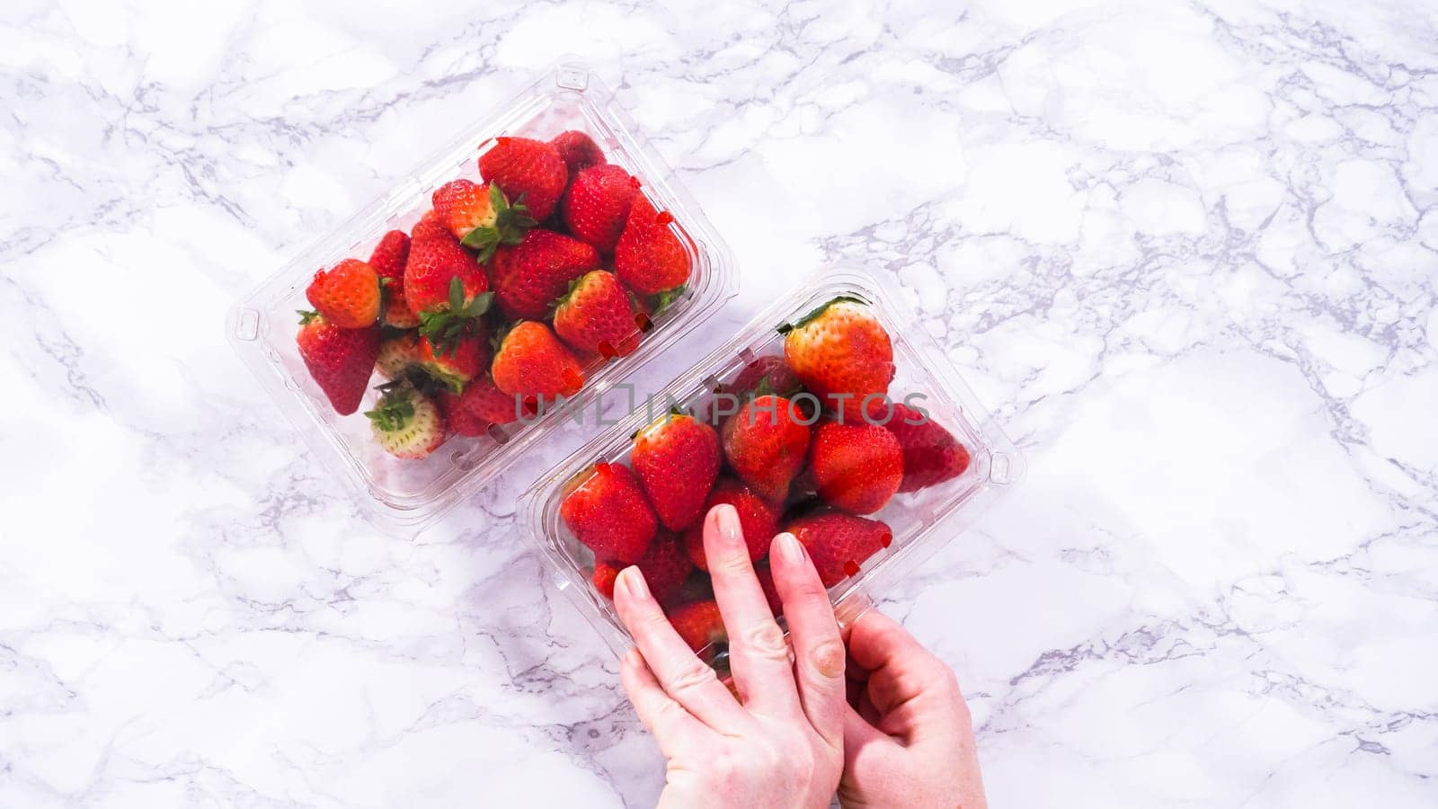 Store-Bought Strawberries in a Plastic Container on the Kitchen Counter by arinahabich