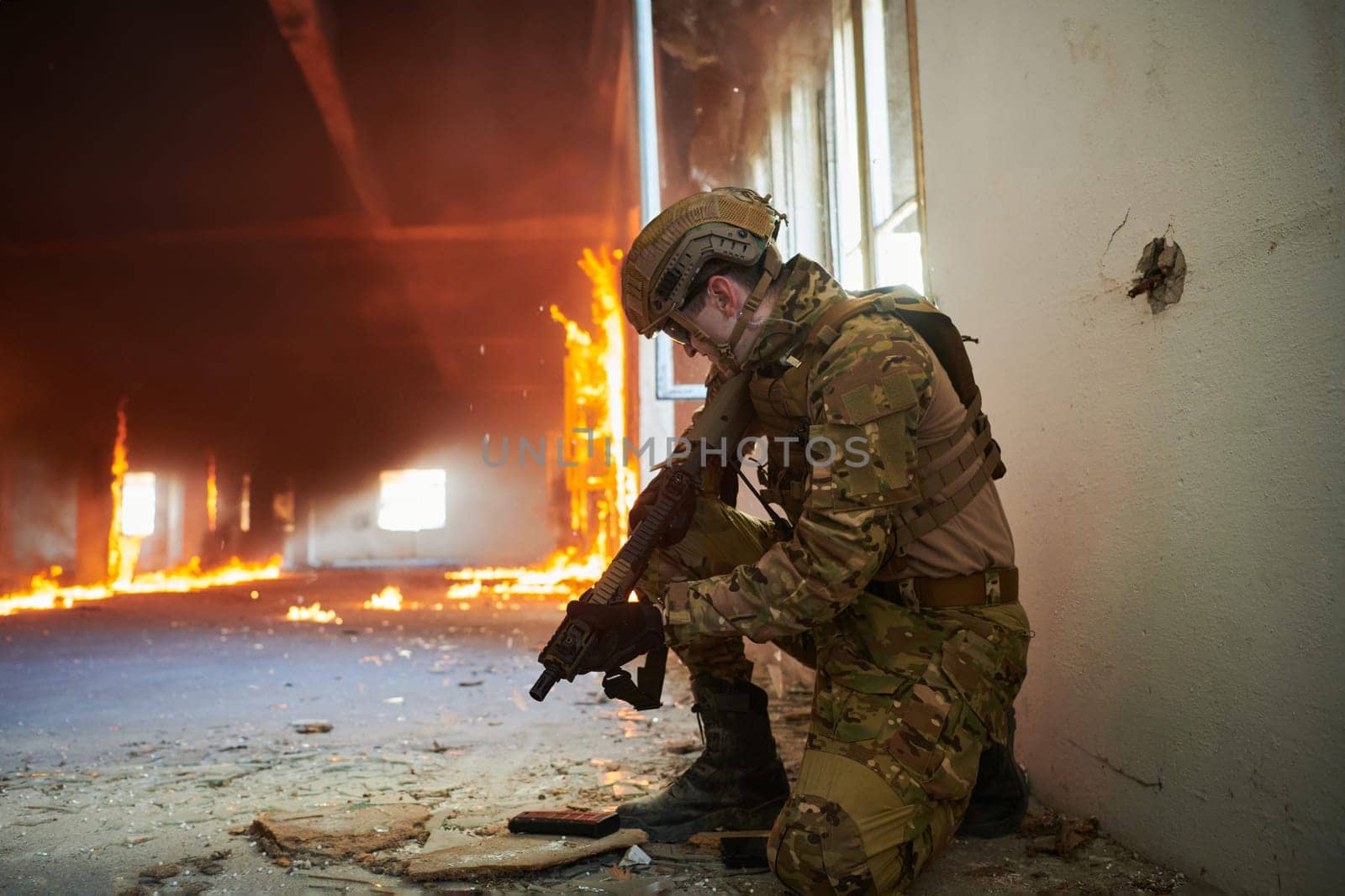 soldier in action near window changing magazine and take cover.