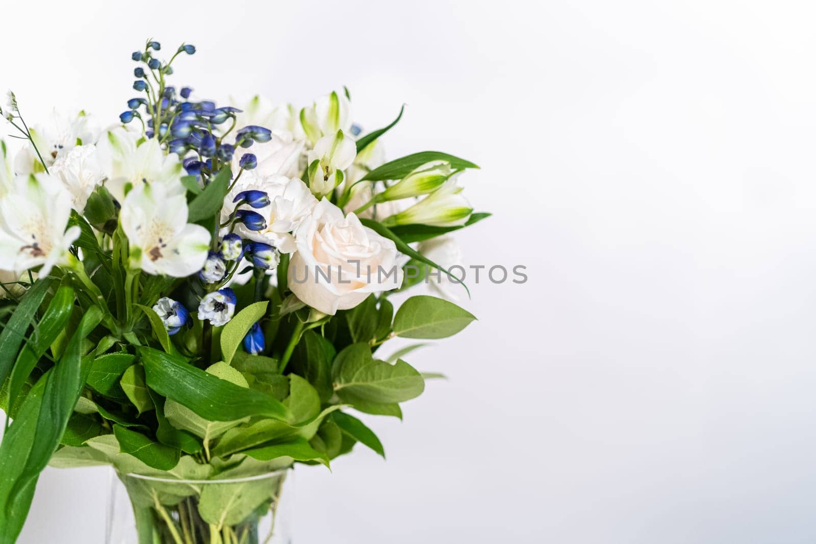 A stunning bouquet featuring fresh white roses and assorted flowers gracefully arranged in a vase, exuding timeless beauty.