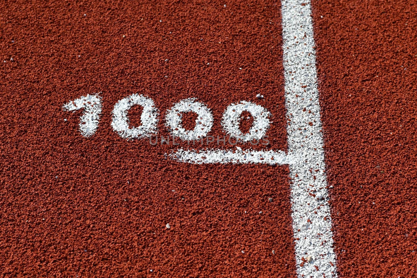 One thousand meter mark on a running track at a stadium