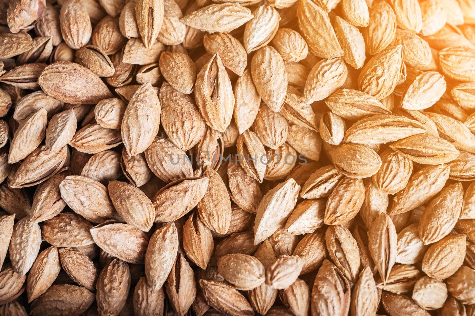 background with unpeeled almond kernels in a shell on a market counter close-up