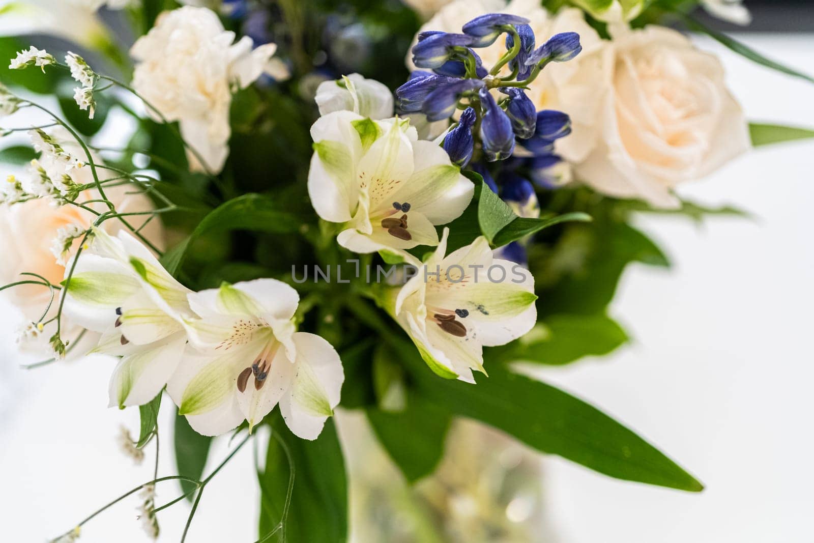 A stunning bouquet featuring fresh white roses and assorted flowers gracefully arranged in a vase, exuding timeless beauty.