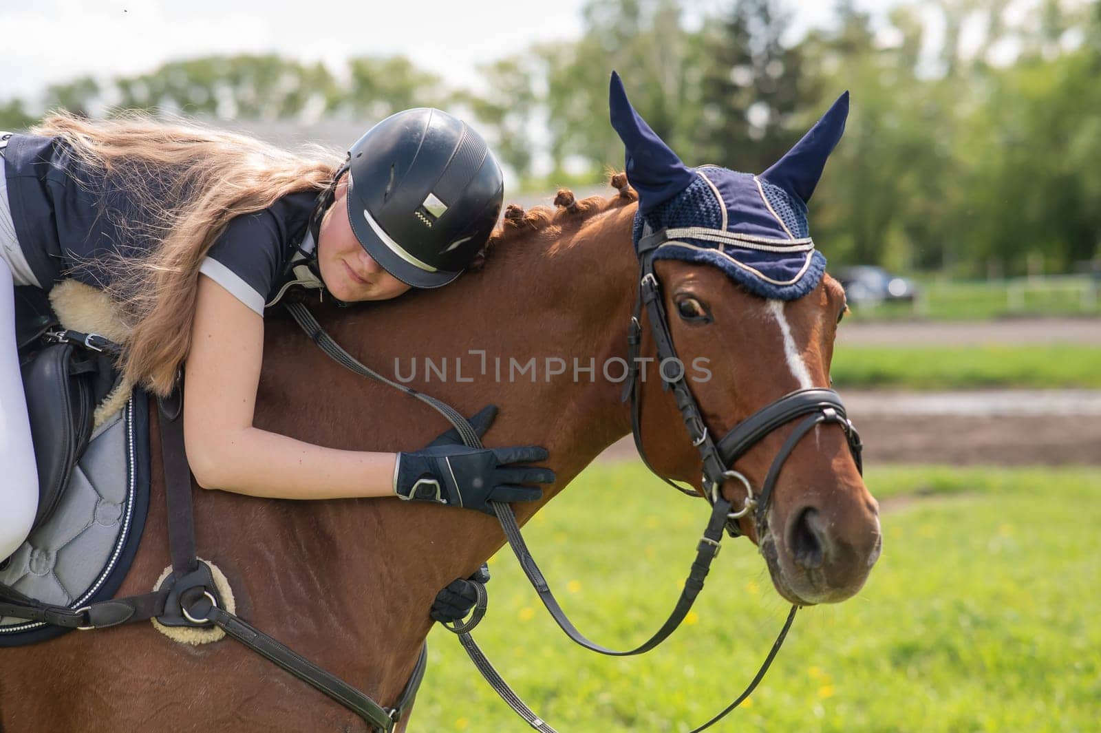 Portrait of a girl jockey hugging her horse