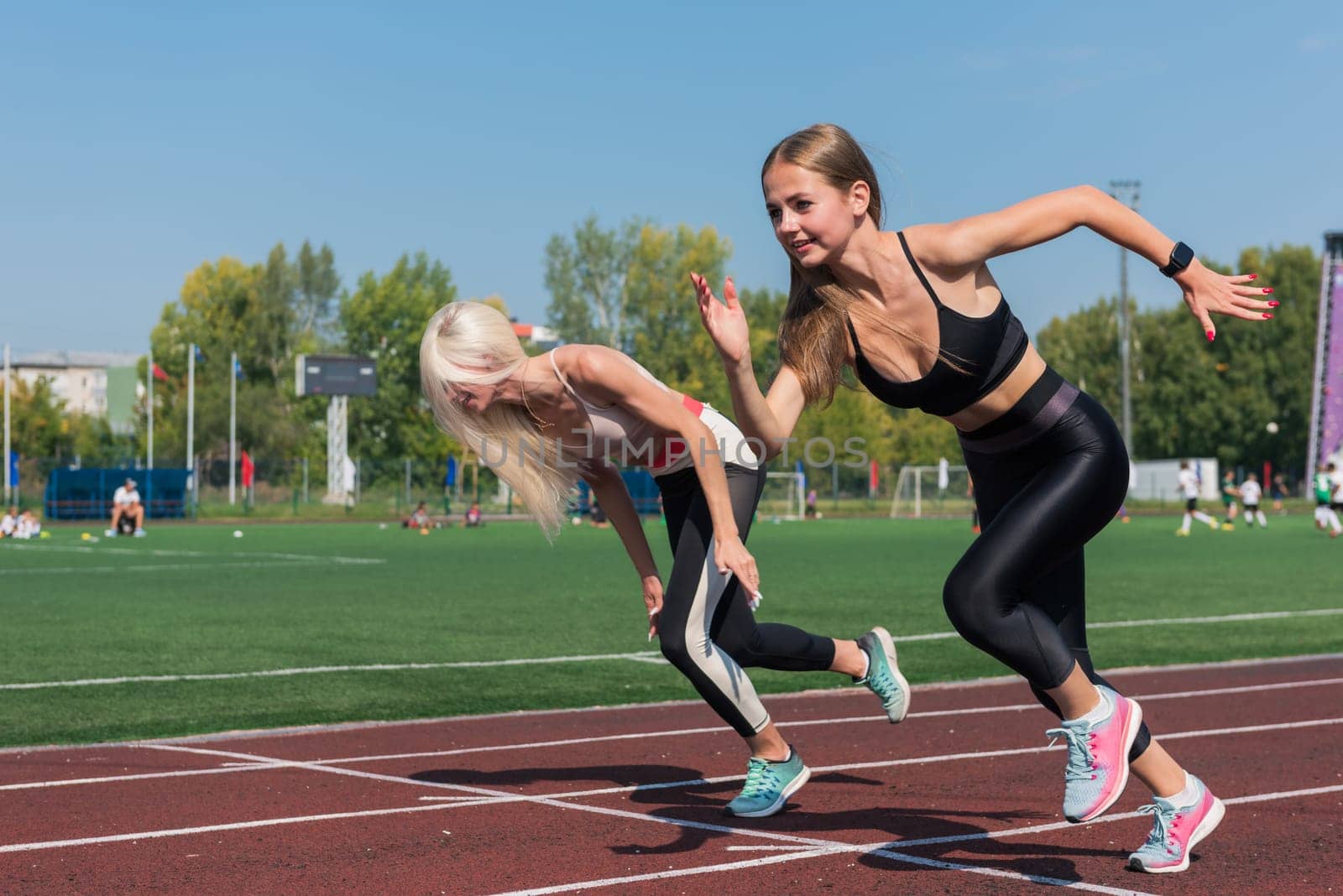 Two athlete young woman runnner are training at the stadium outdoors