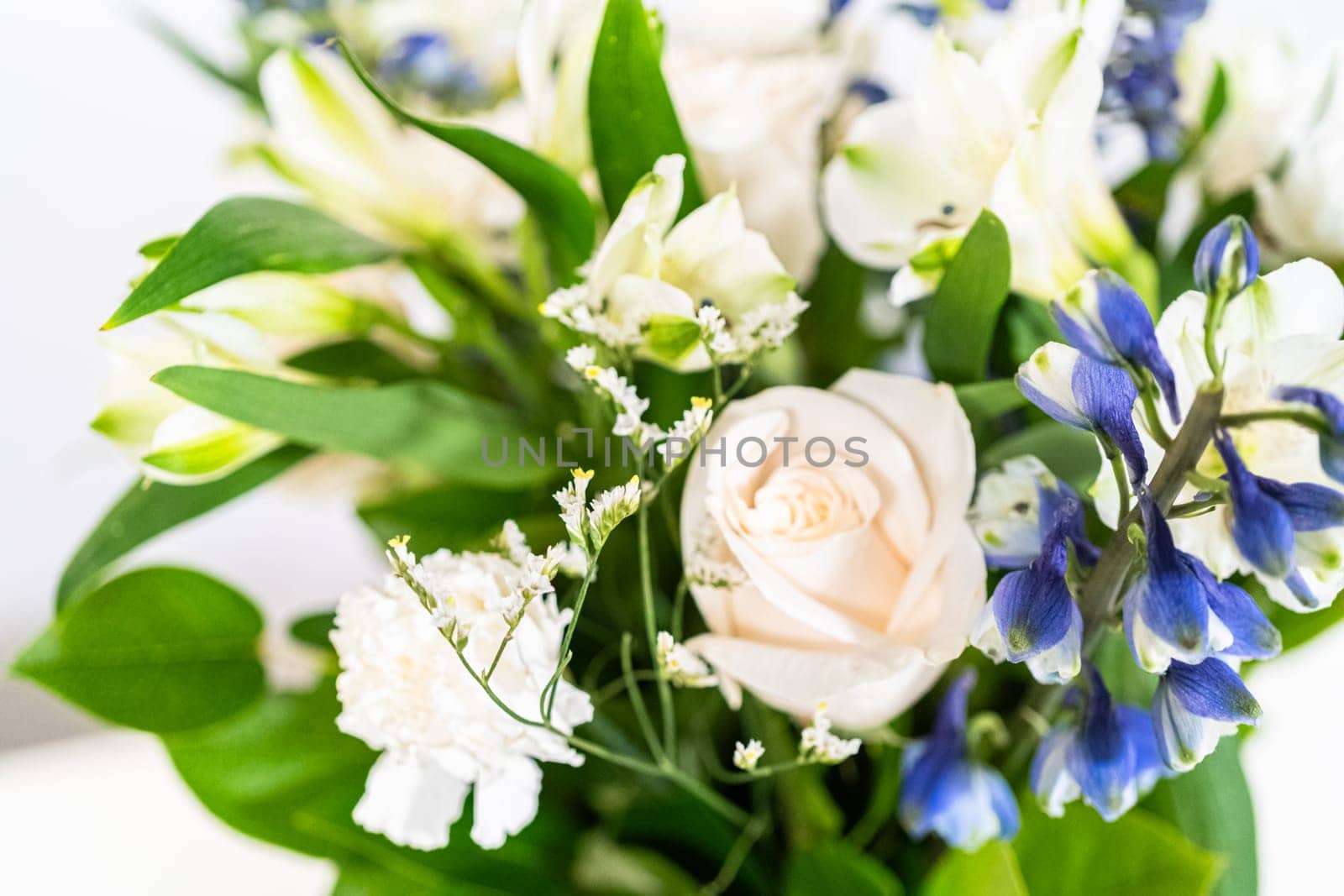 A stunning bouquet featuring fresh white roses and assorted flowers gracefully arranged in a vase, exuding timeless beauty.