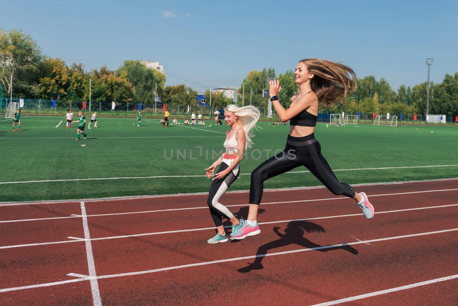 Two athlete young woman runnner are training at the stadium outdoors