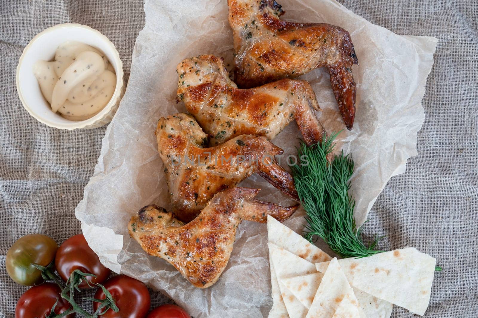 Ready spicy grilled chicken wings with greens and tomato. Summer rest concept