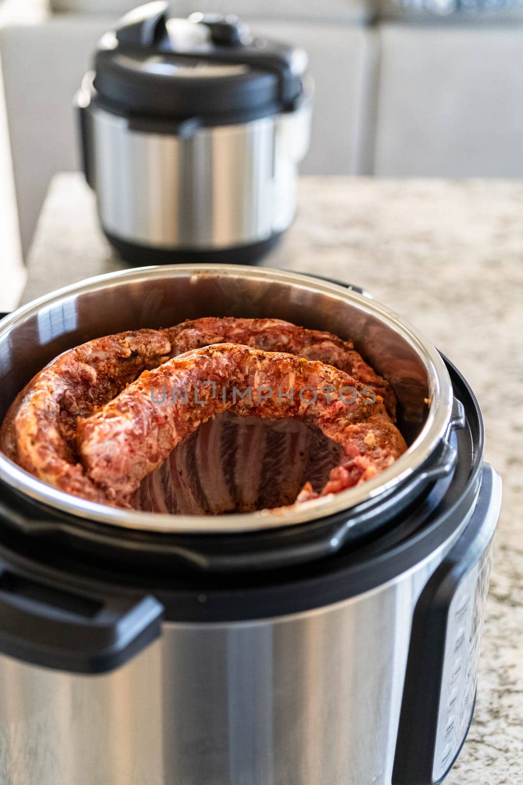 In a sleek modern kitchen, we're adding an extra layer of flavor to succulent baby back ribs by infusing them with a medley of spices in a multicooker—a mouthwatering feast in the making.